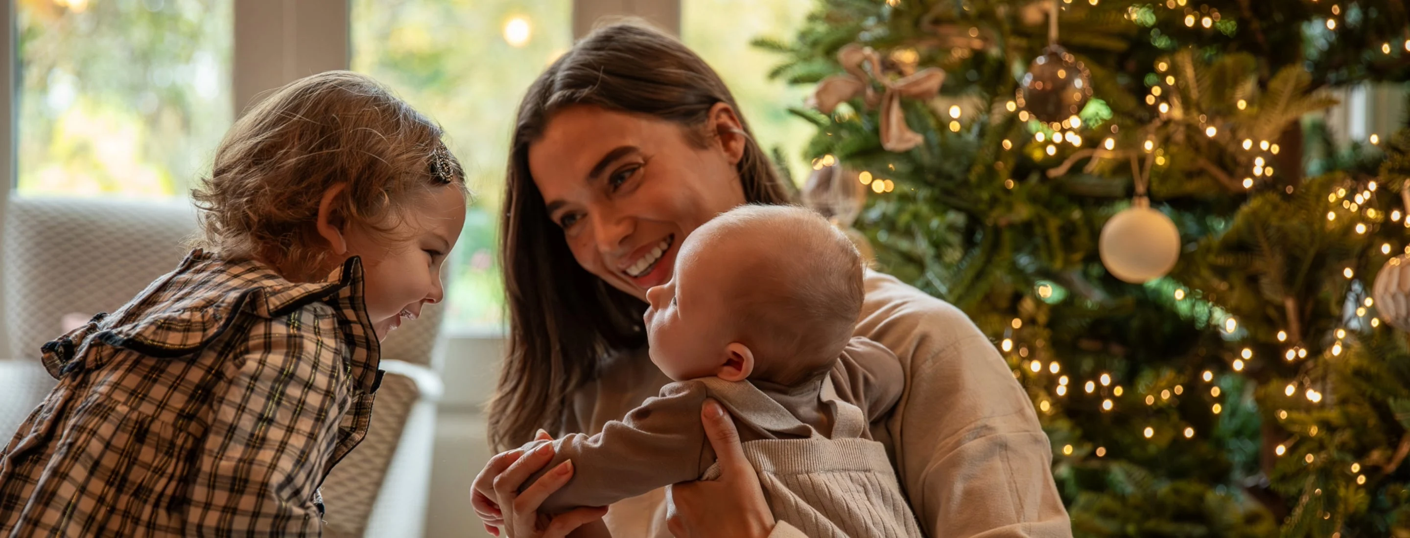 Christmas Gift Guide - Family by the tree on Christmas Day