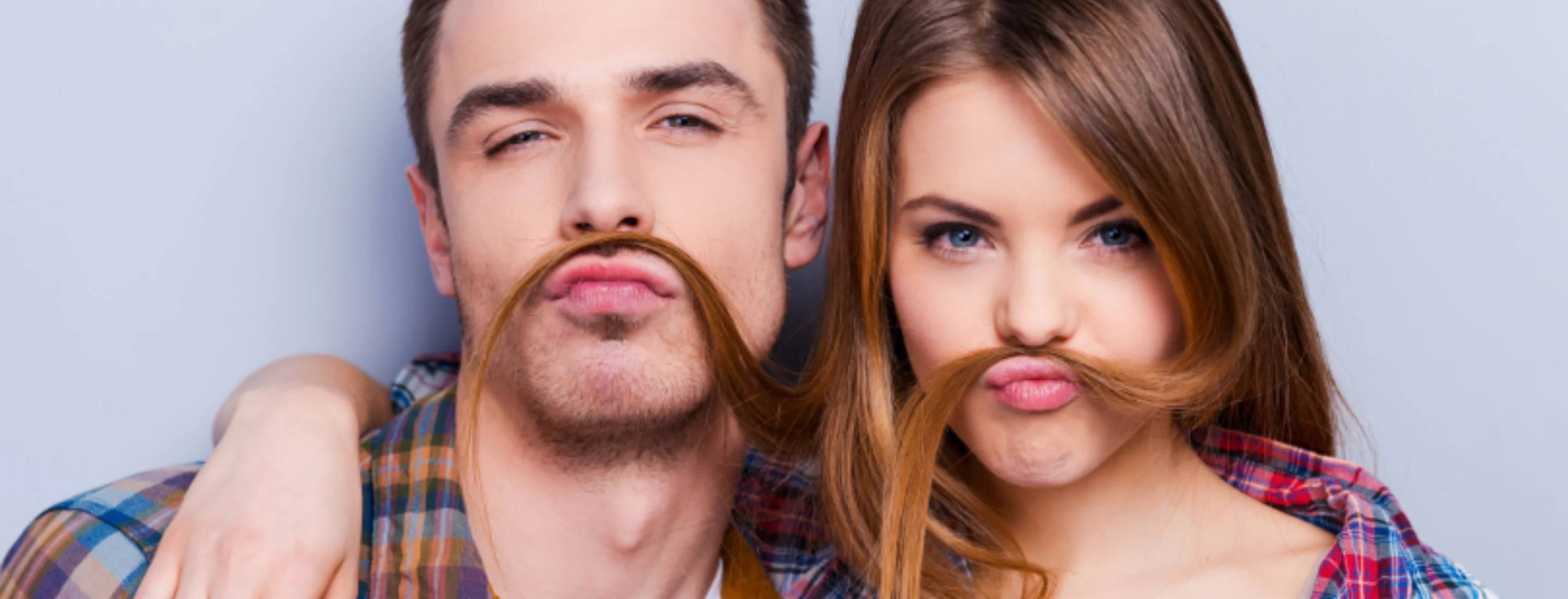 a man and woman using her hair to simulate a moustache