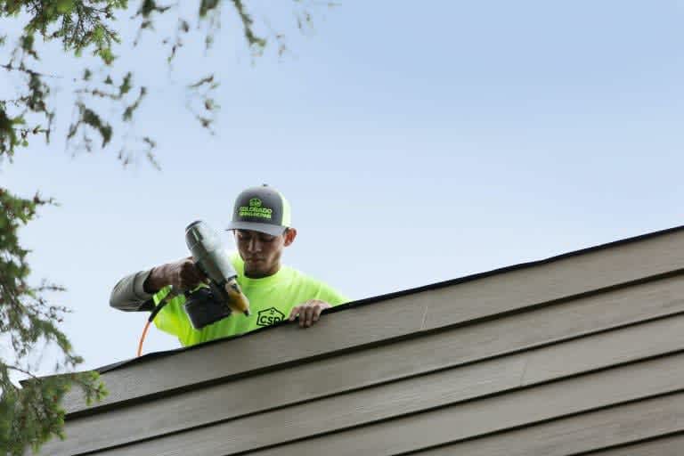 Colorado Siding Repair employee installing siding