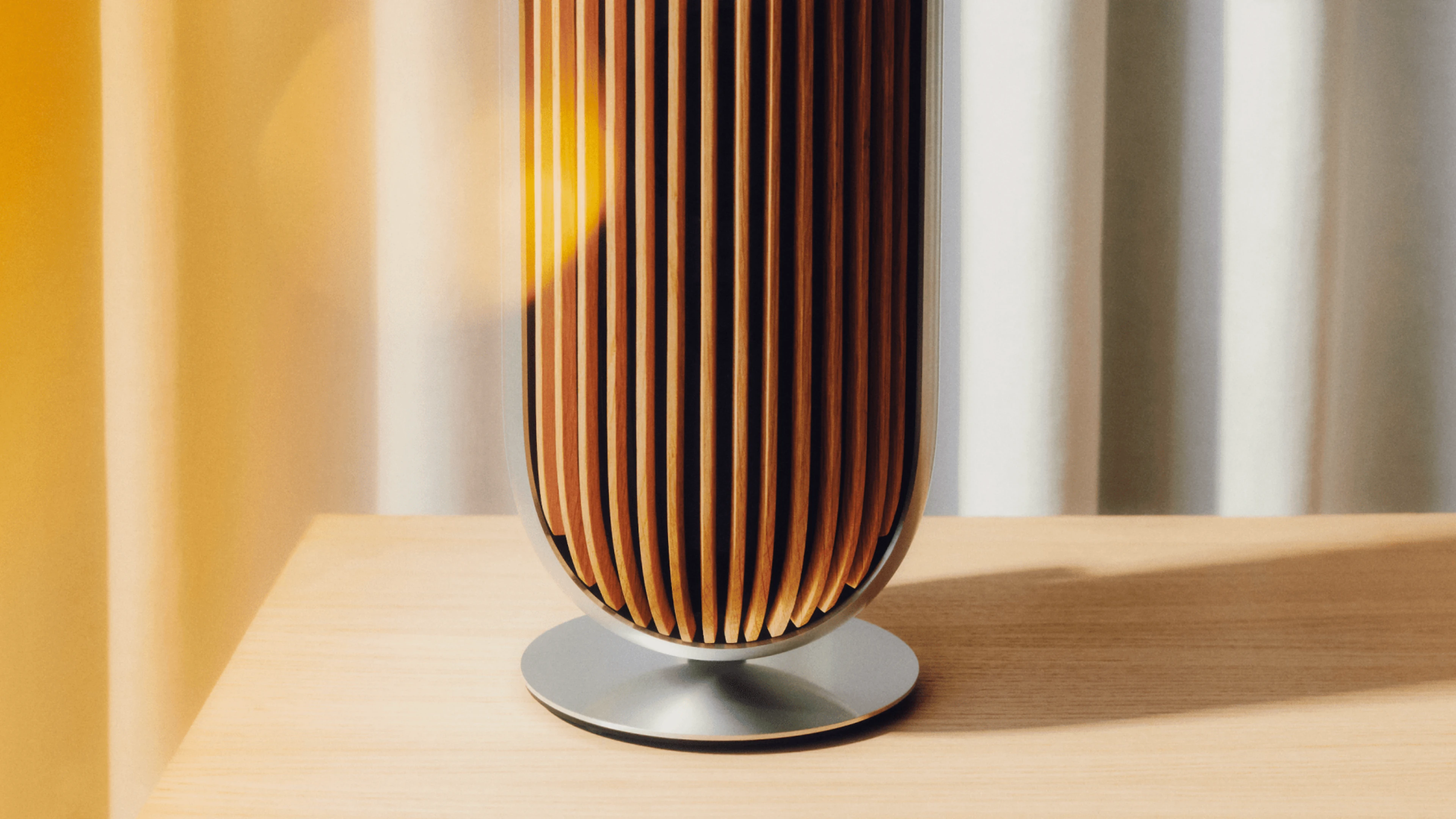 Image of the Beolab 8 speaker in natural aluminium with oak cover standing on a table