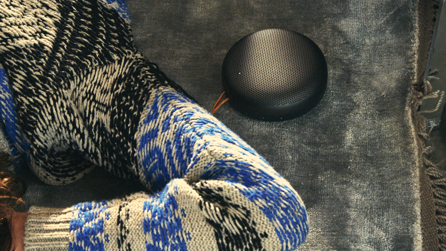 Beosound A1 in black anthracite on a grey carpet, seen from the top