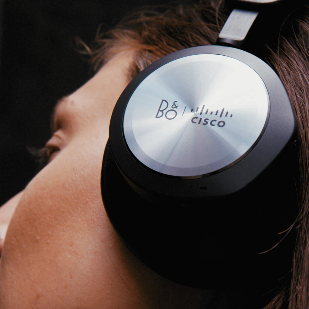 Image of woman wearing Bang & Olufsen Cisco headphones