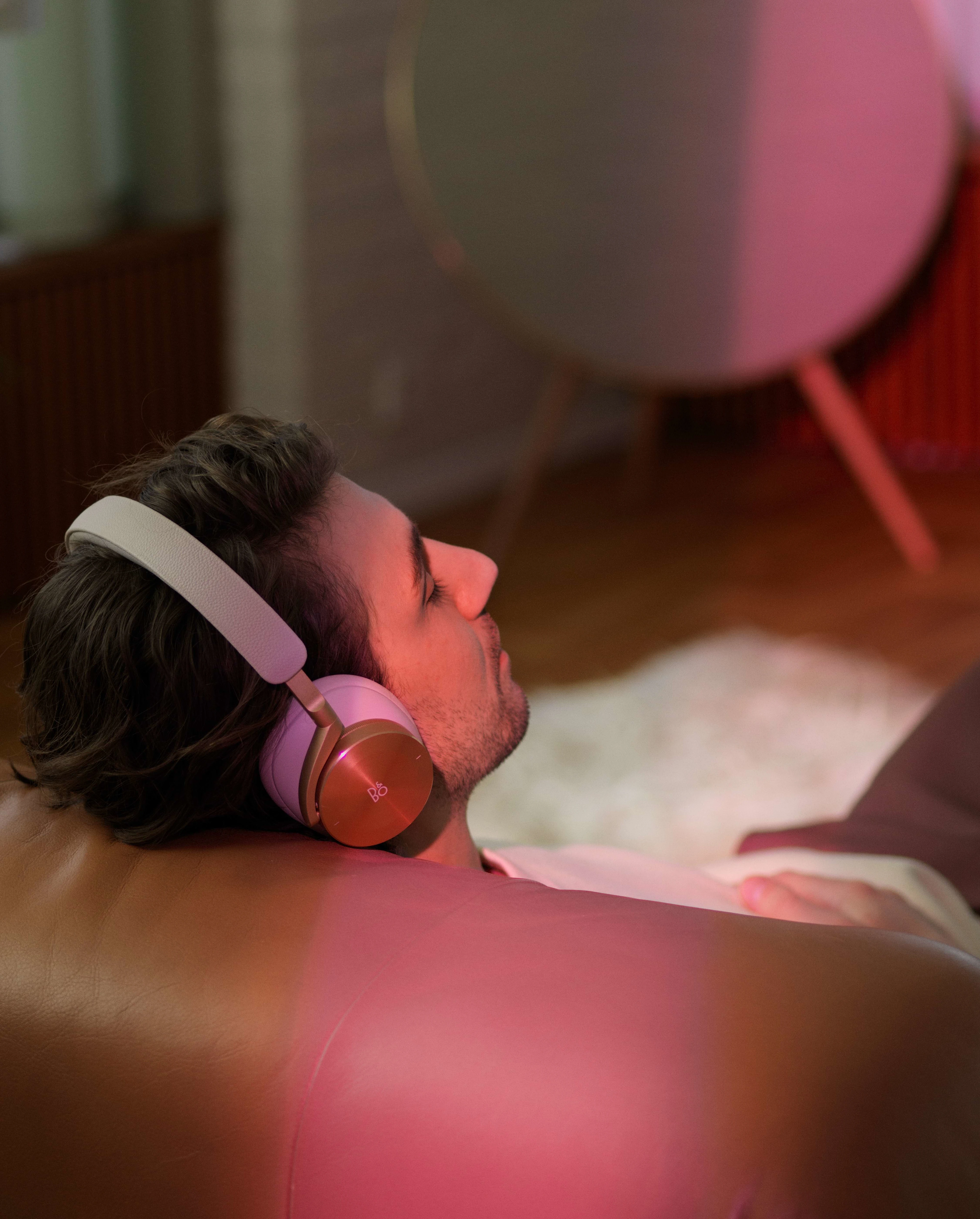 Man on the couch wearing Beoplay H95 Gold Tone