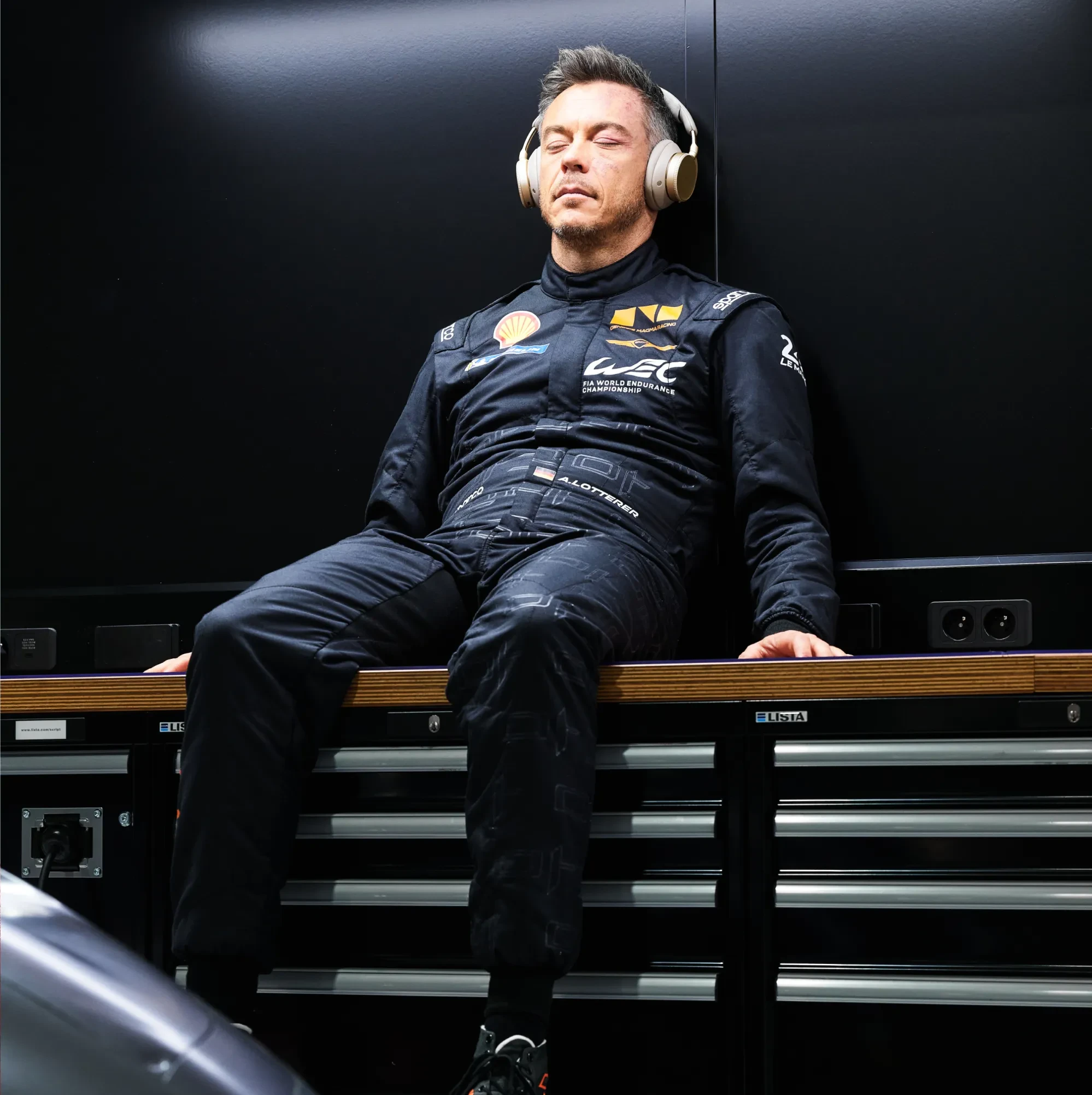 Un piloto de Genesis Magma Racing disfrutando de música, con los ojos cerrados y con los auriculares Bang & Olufsen Beoplay H100