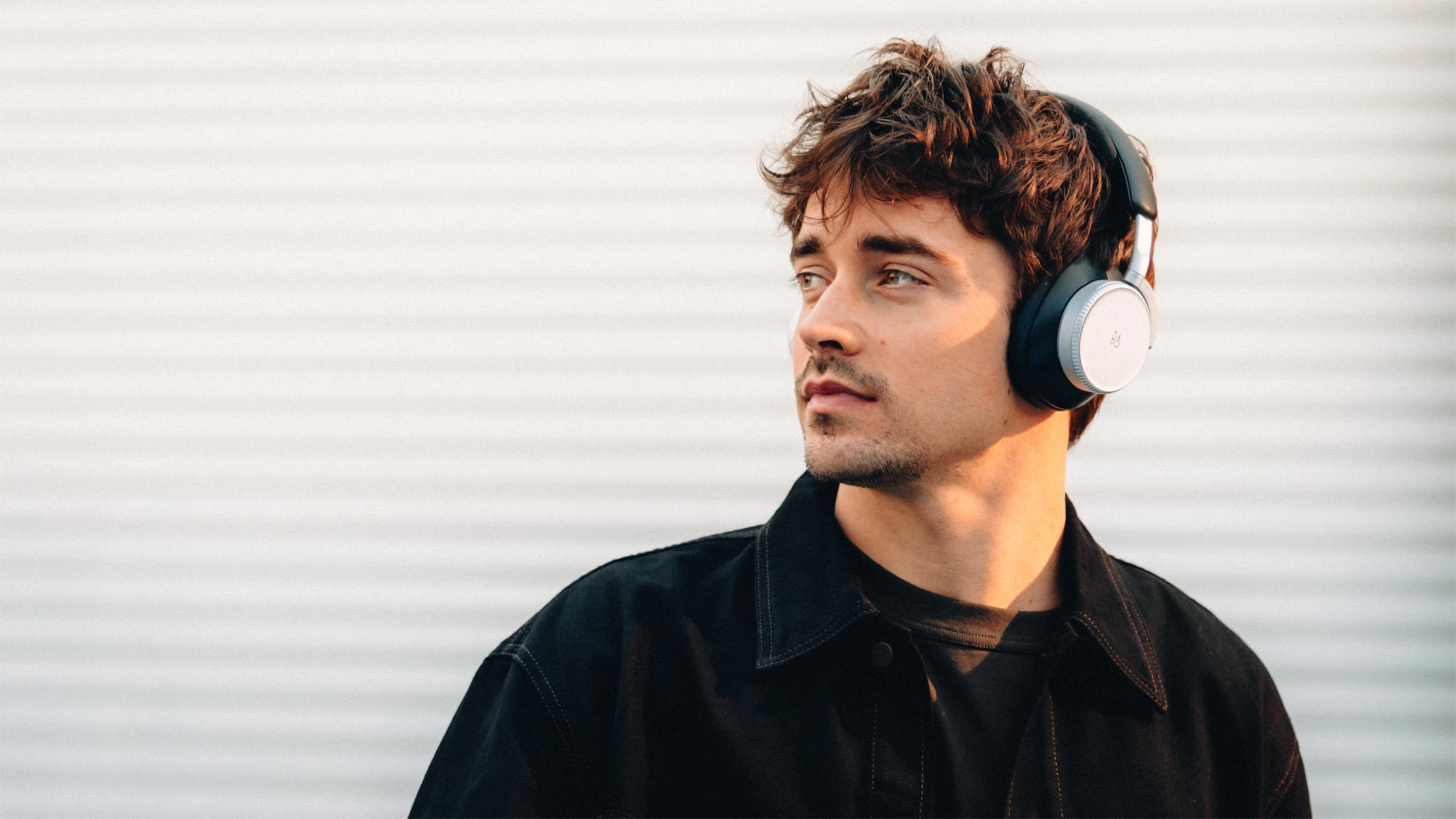 Charles Leclerc wearing Beoplay H100 in sand 