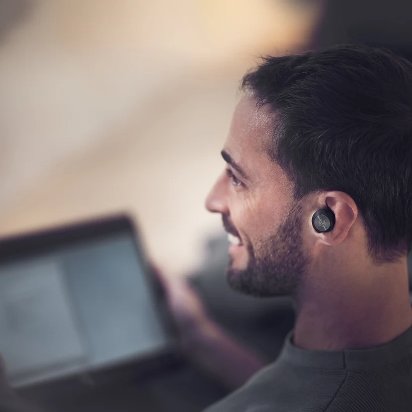 A man wearing Beoplay EQ while working from home