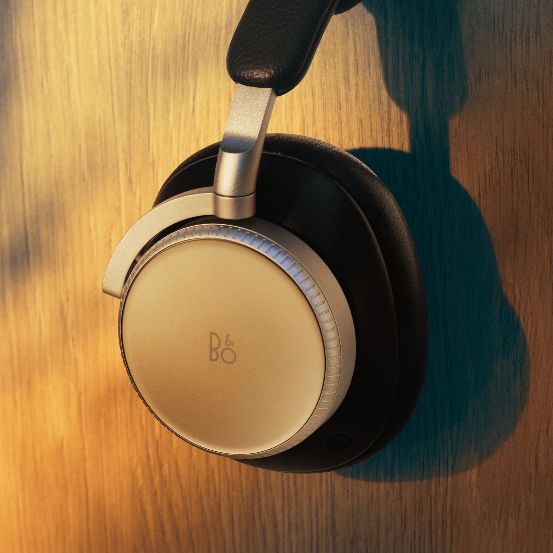 Beoplay H100 next to a wooden wall