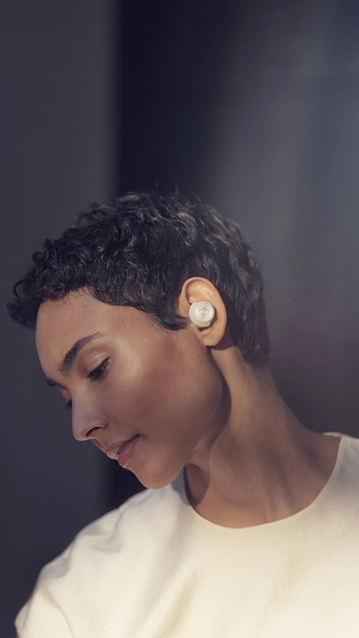 A woman wearing Beoplay EQ noise cancelling earphones