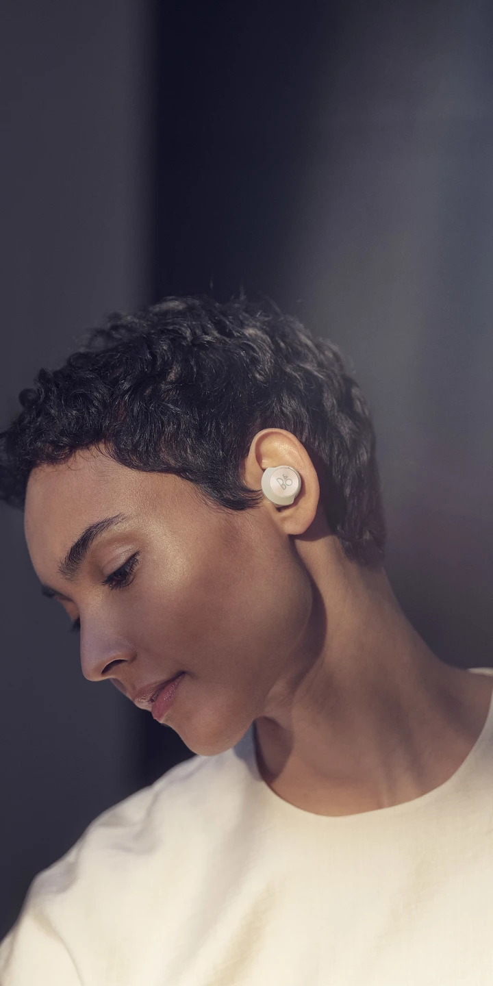 A woman wearing Beoplay EQ noise cancelling earphones