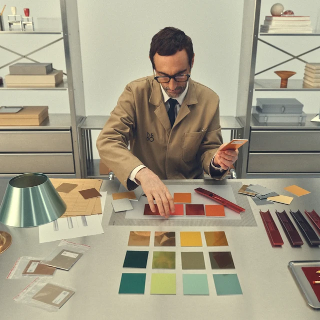 A man selecting from multiple color samples from B&O Atelier