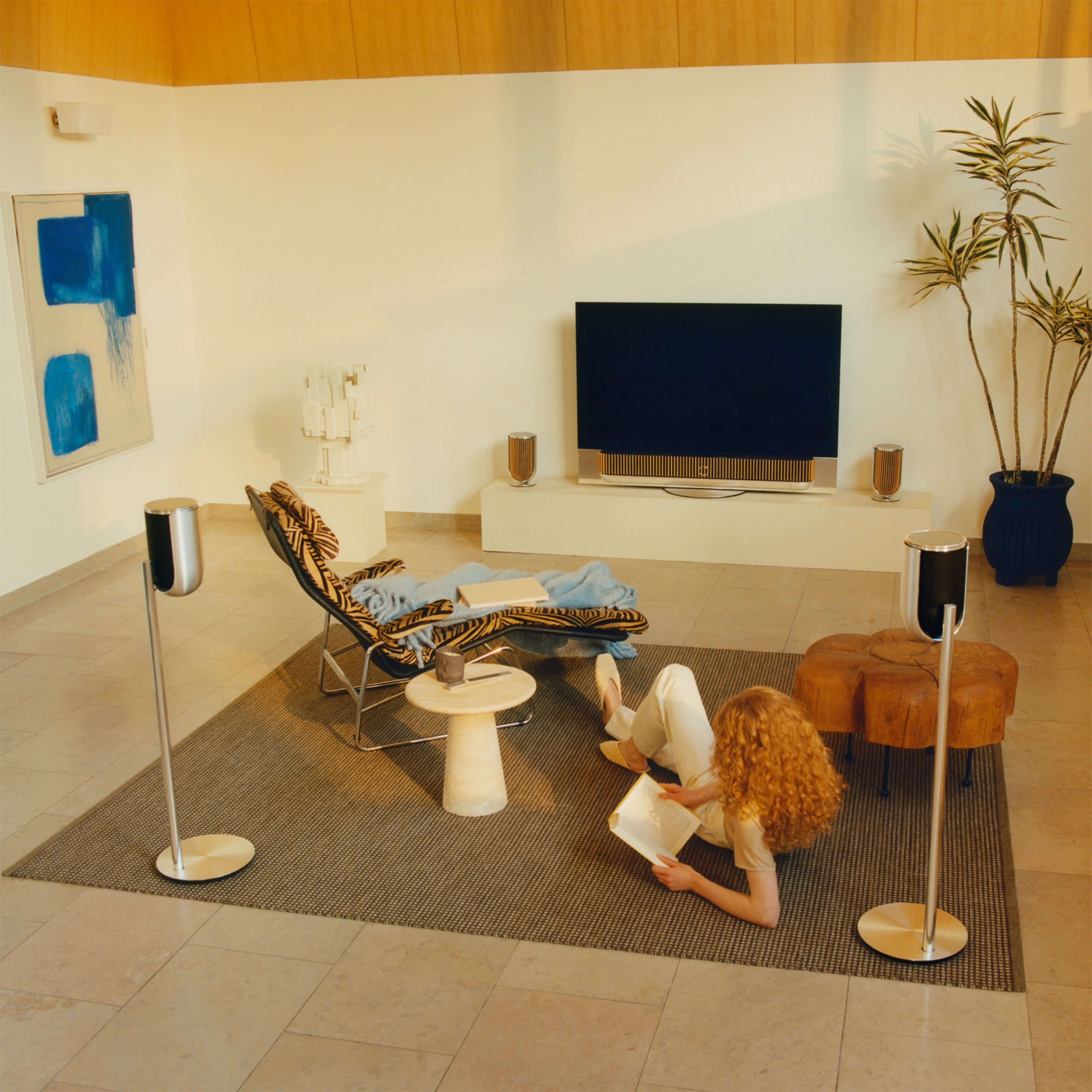 Two people sitting in a living room surrounded by B&O products