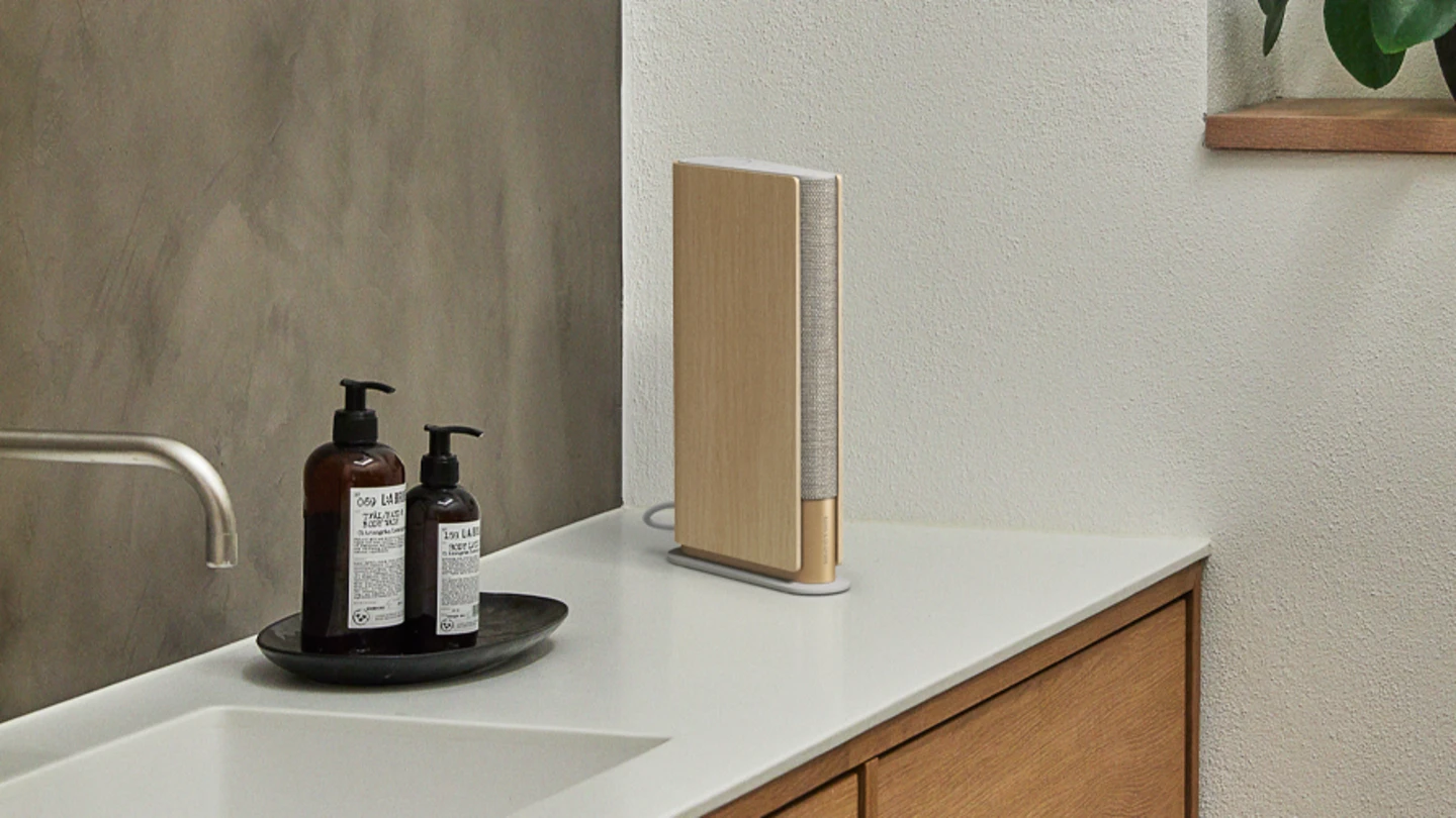Beosound Emerge Gold Tone - Light Oak speaker on a table in the home office