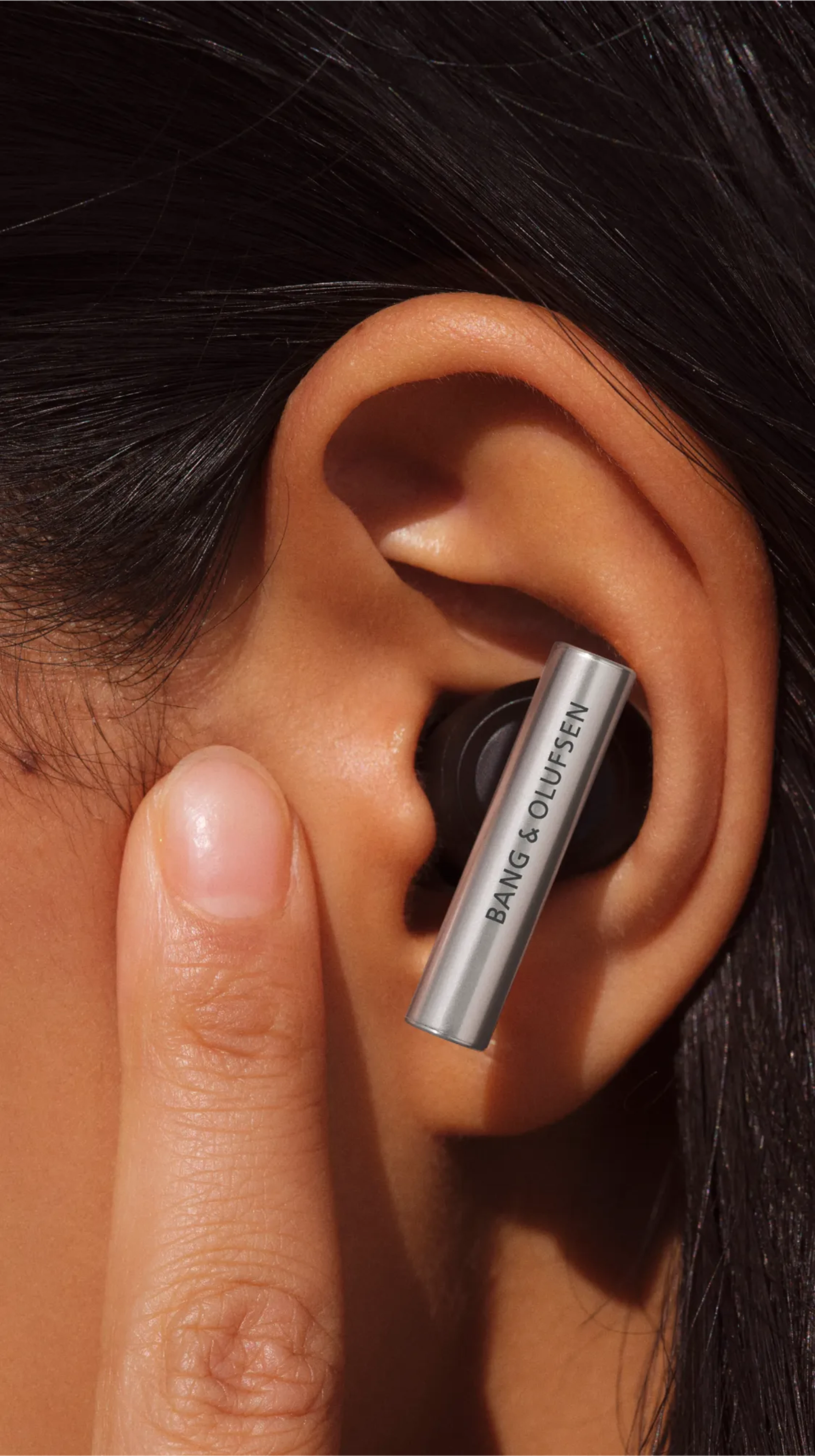 Beo Grace 插入耳內,一位女士正在觸摸她耳前的肌膚