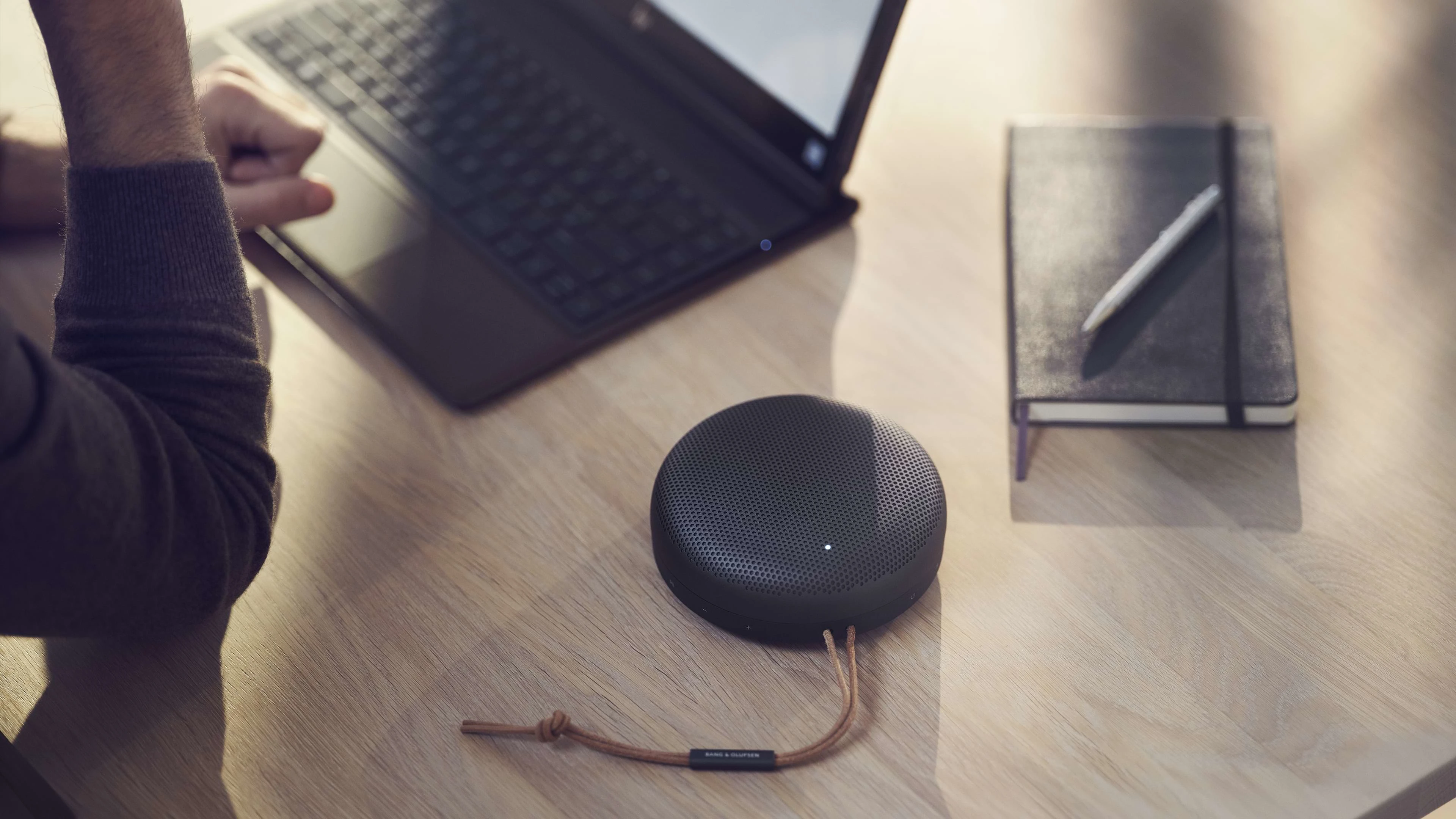 Beosound a1 sobre un escritorio de madera