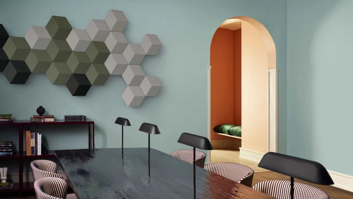 A livingroom in green colours with a Beosound Shape hanging on the end wall