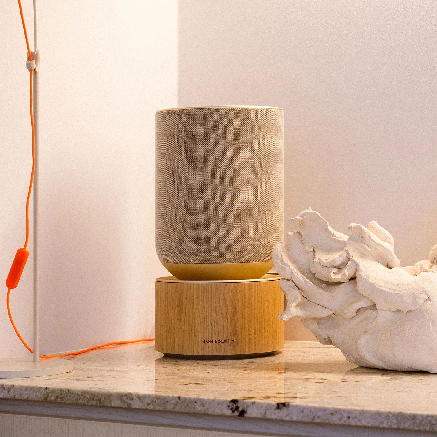 Beosound Balance in oak on a marble surface