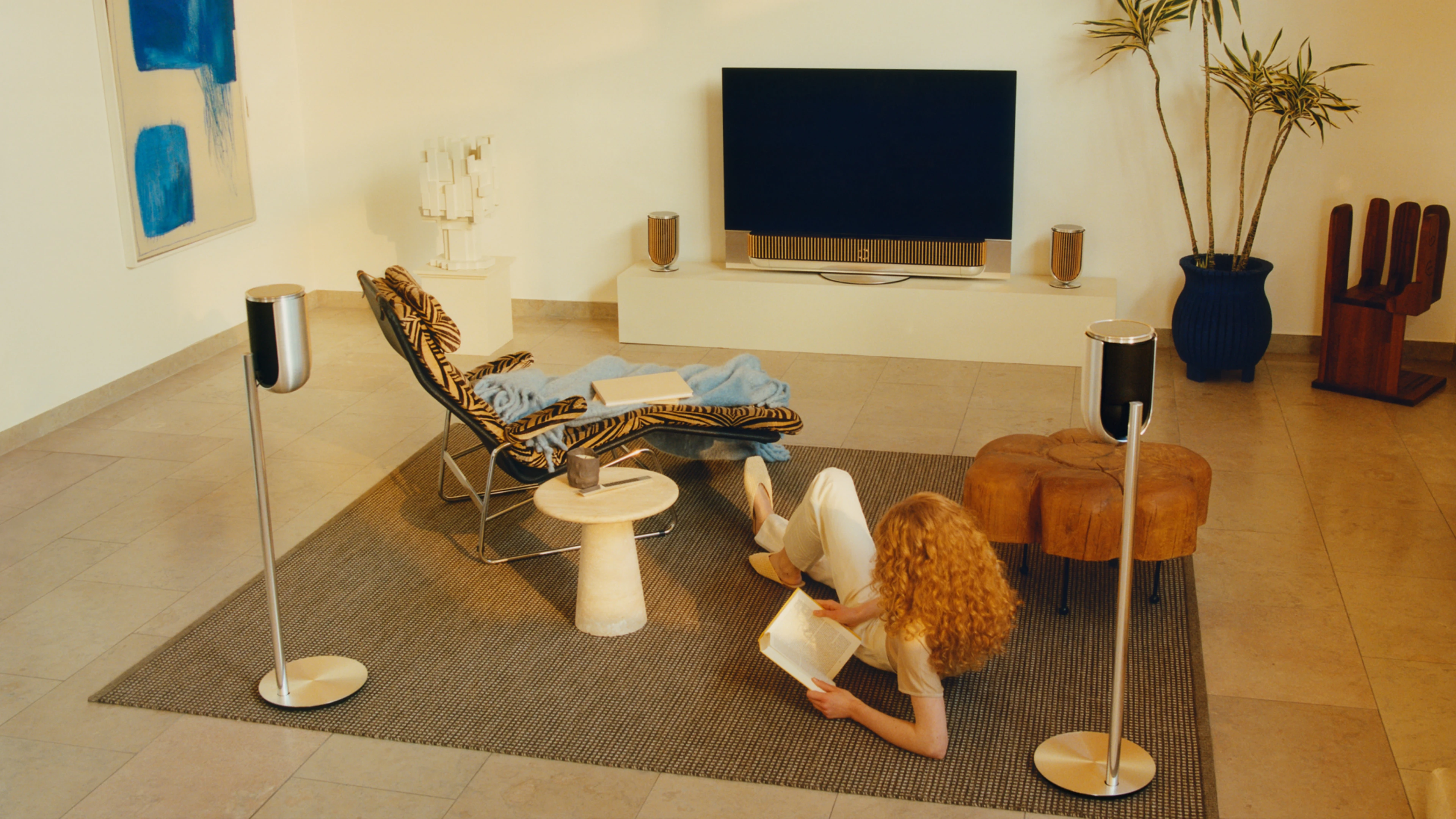 Woman sitting in living room with a Bang & Olufsen Sound system