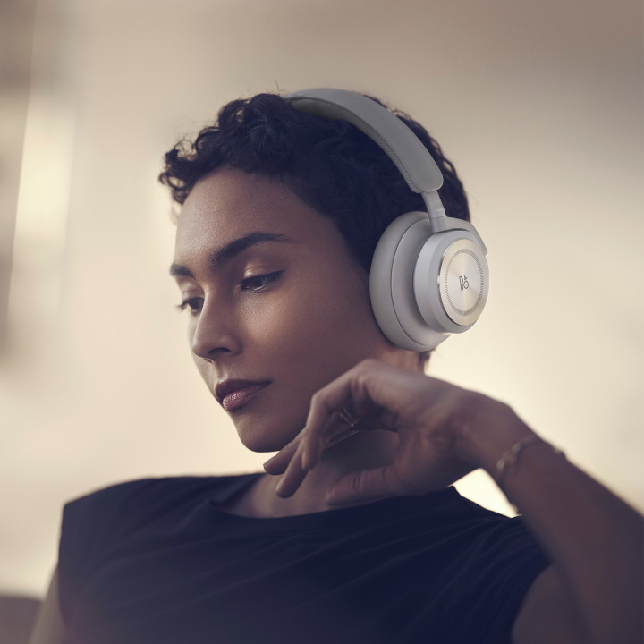 A woman wearing the over-ear headphones Beoplay HX