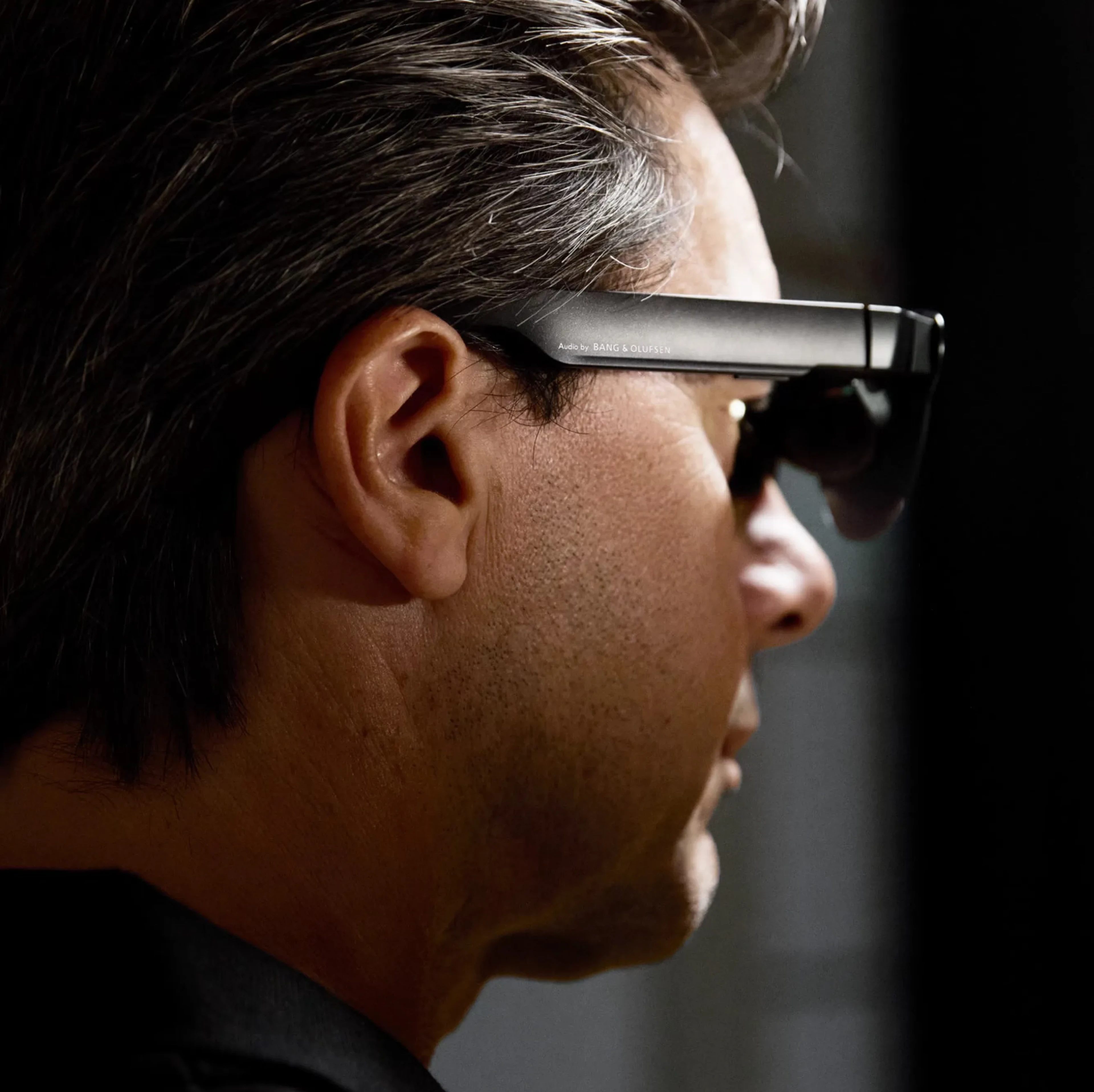 A man wearing RayNeo glasses with Bang and Olufsen sound