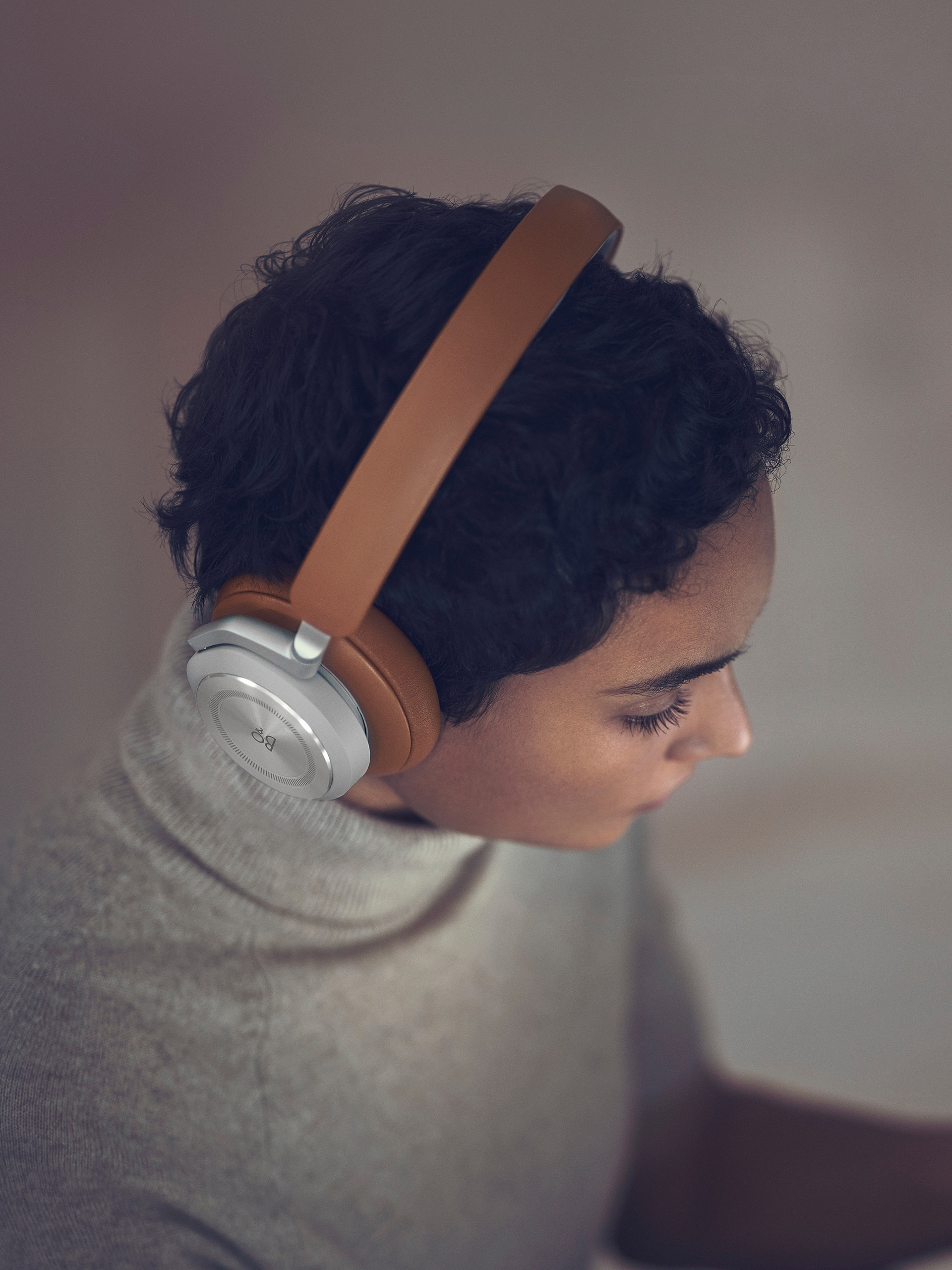 A woman wearing Beoplay HX Timber while working