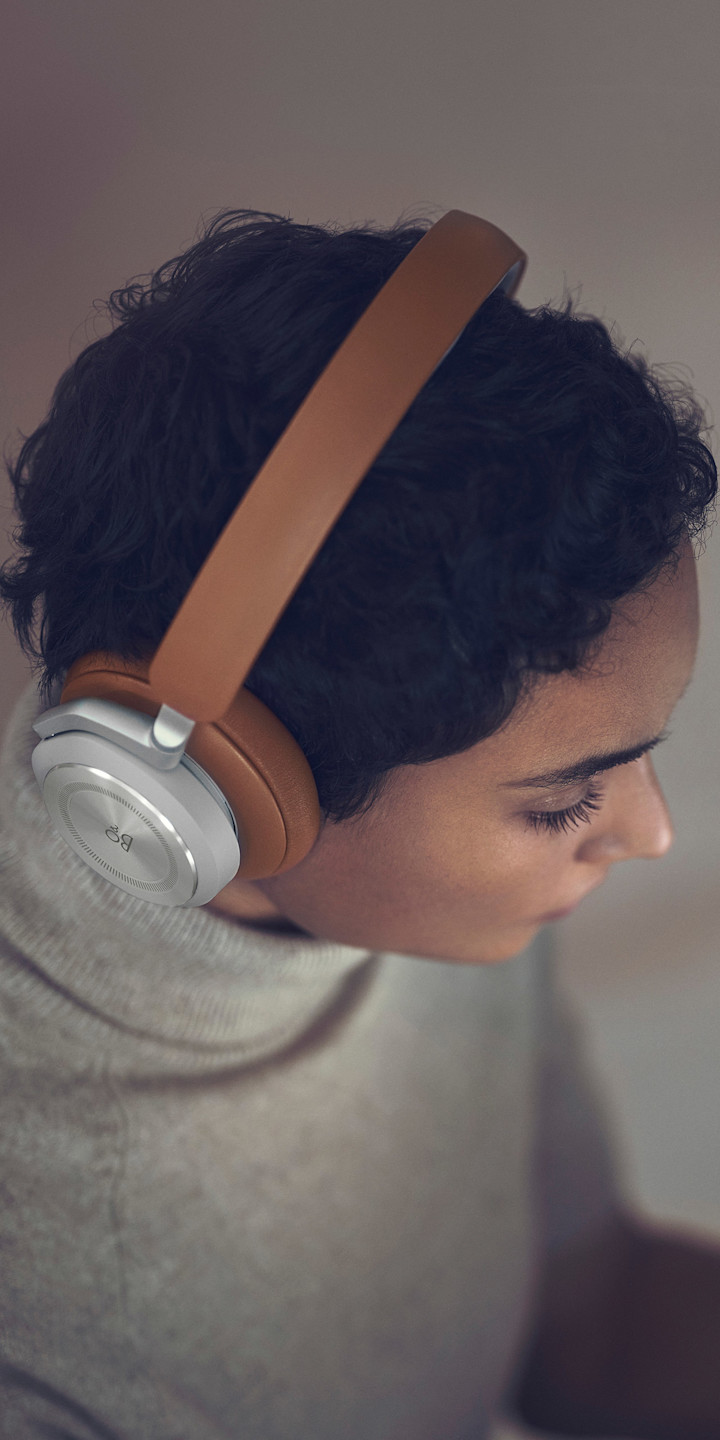 A woman wearing Beoplay HX Timber while working