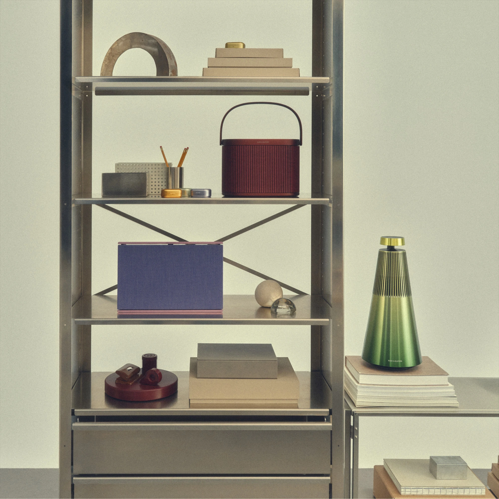 A customized Beosound Level and Beosound A5 on a metal shelf, next to a gradient green Beosound 2