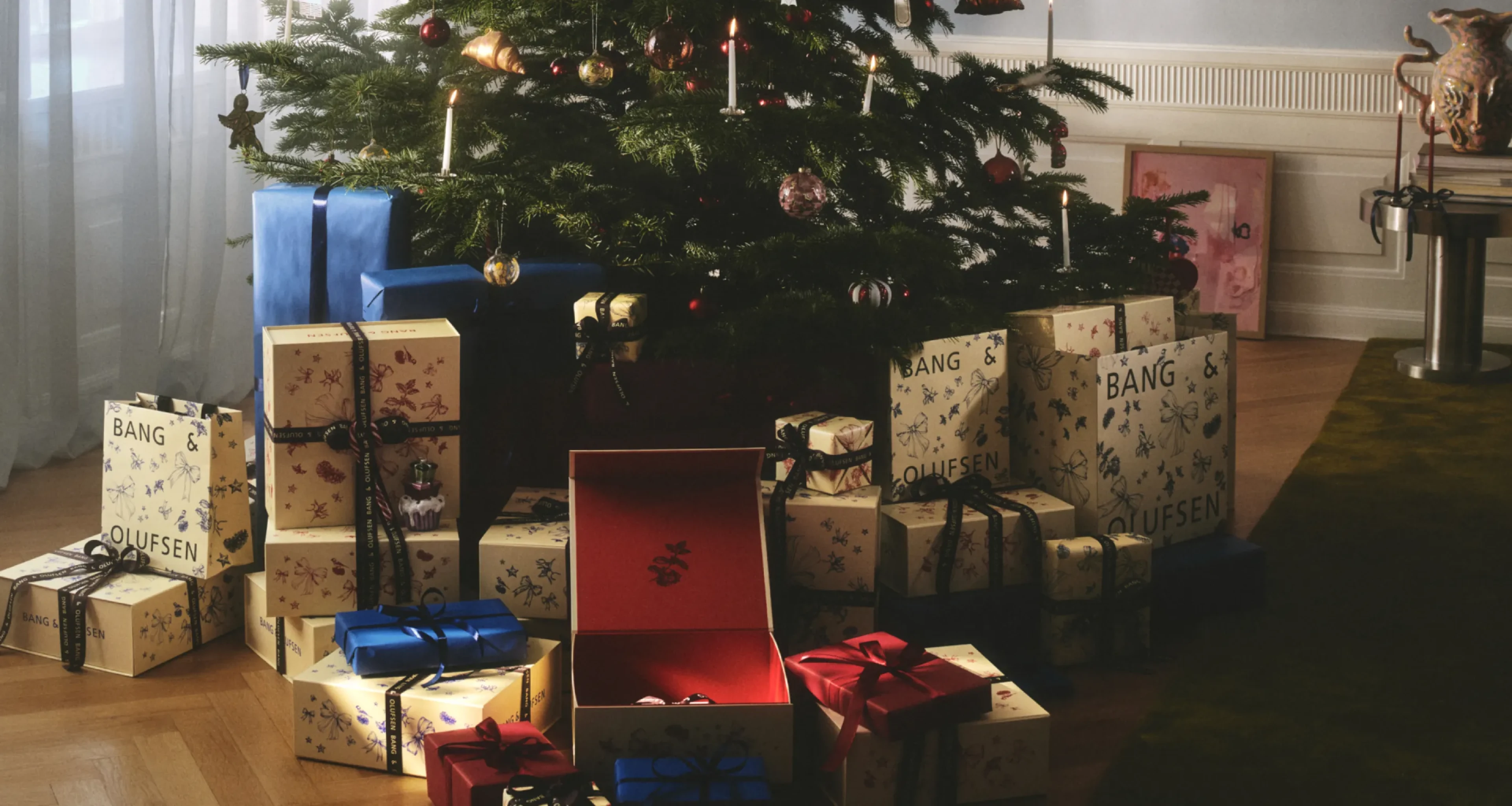 Decorated Christmas tree with wrapped B&O gifts underneath.