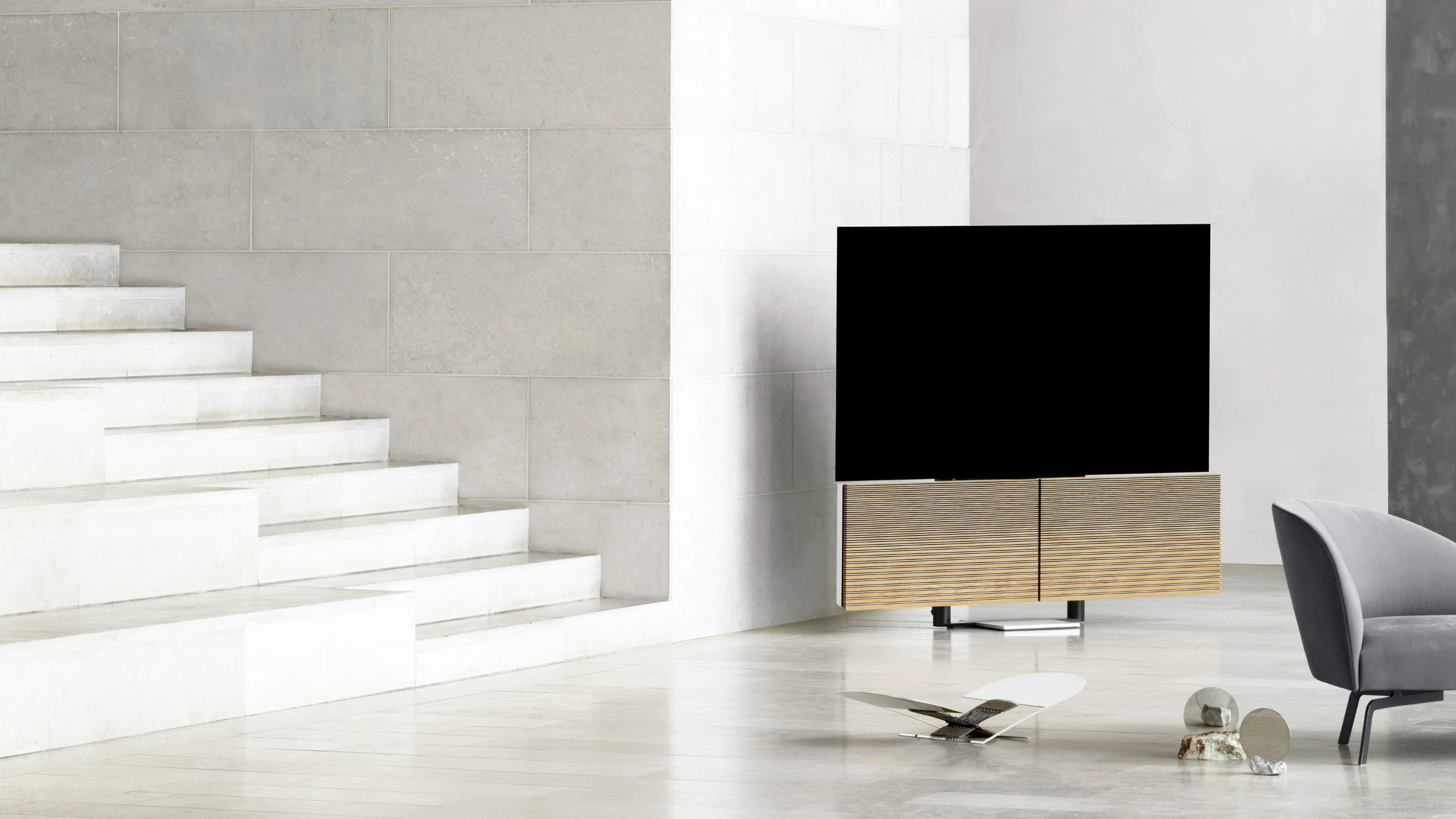 Beovision Harmony placed in the corner of a space next to the stairs