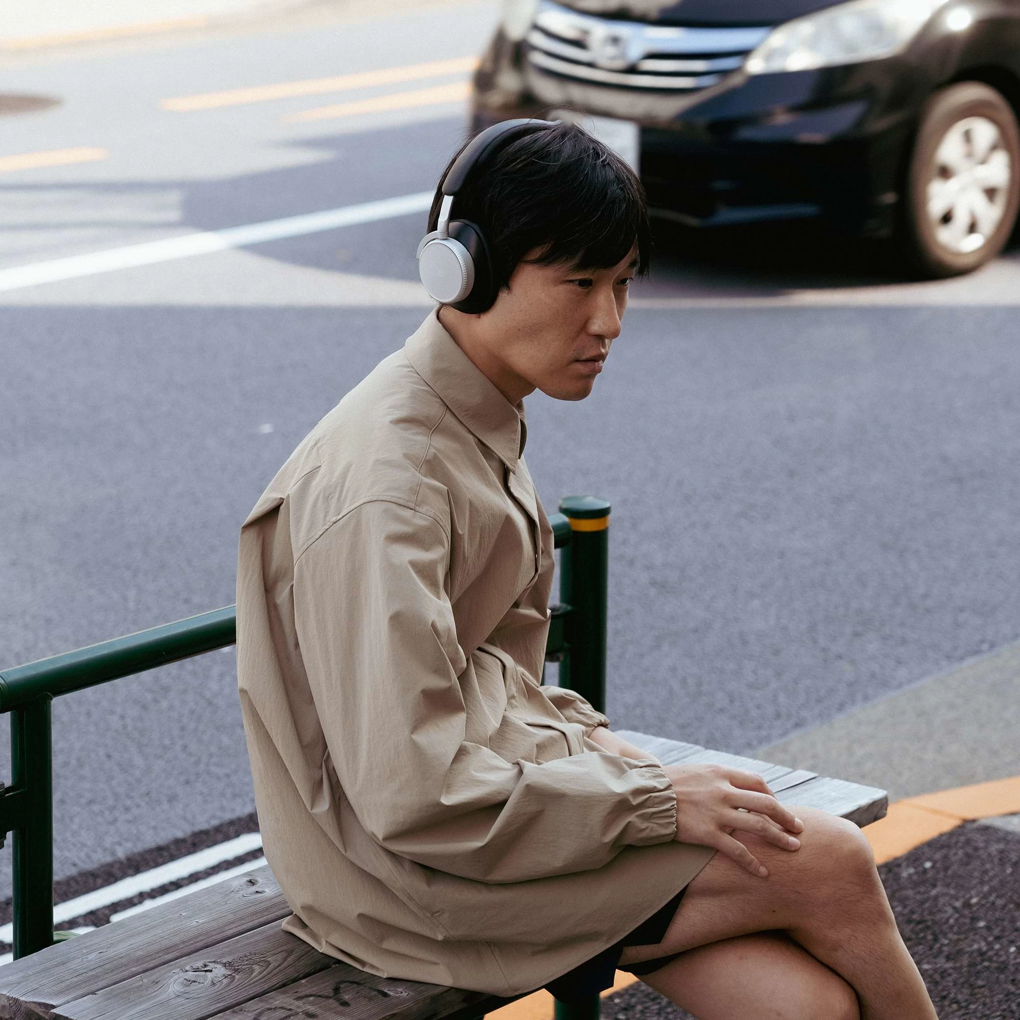 Shuta Hasunuma sitting on a bench with the Beoplay H100