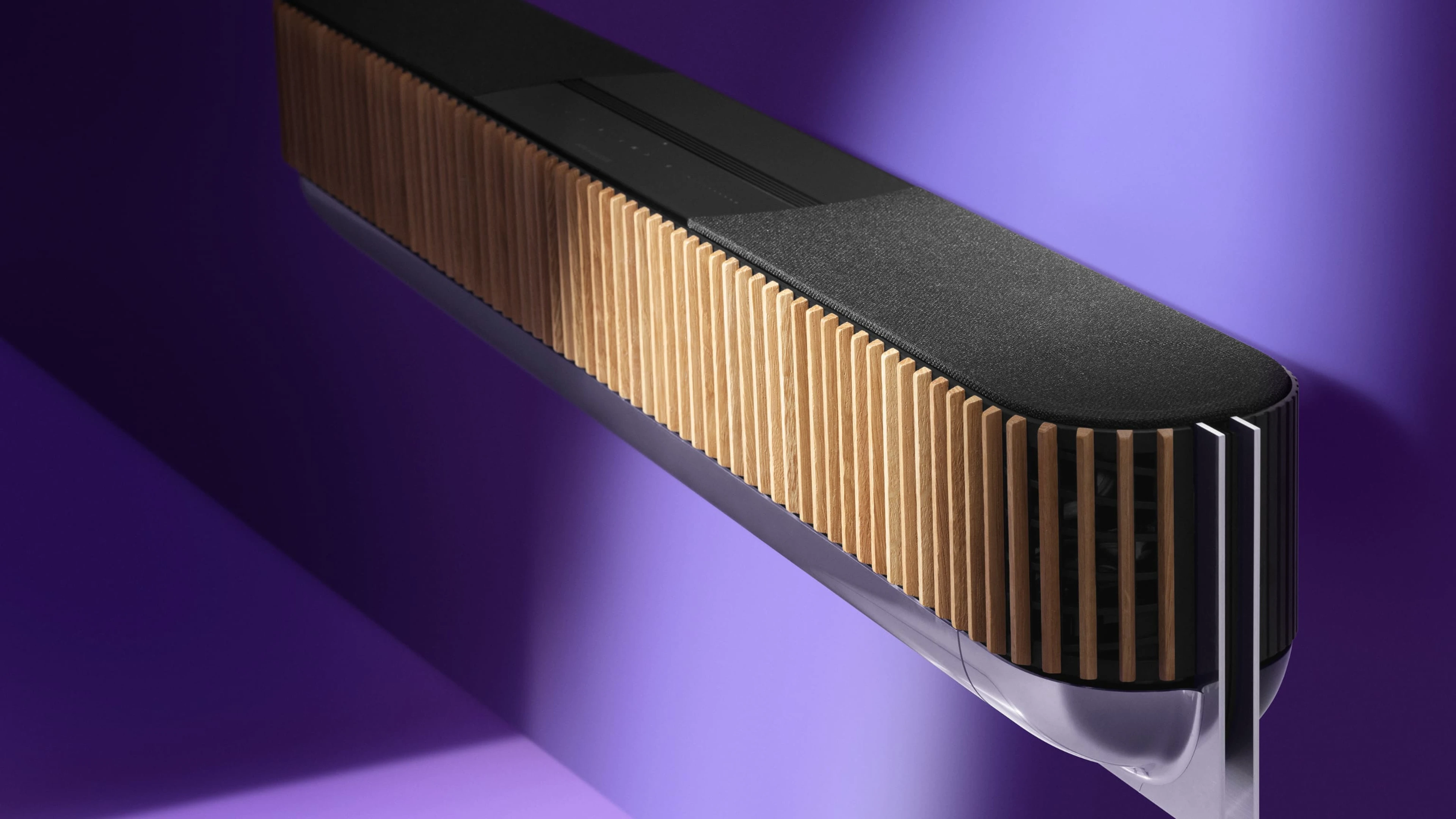 Beosound theatre in natural aluminum with oak front cover attached to a purple wall