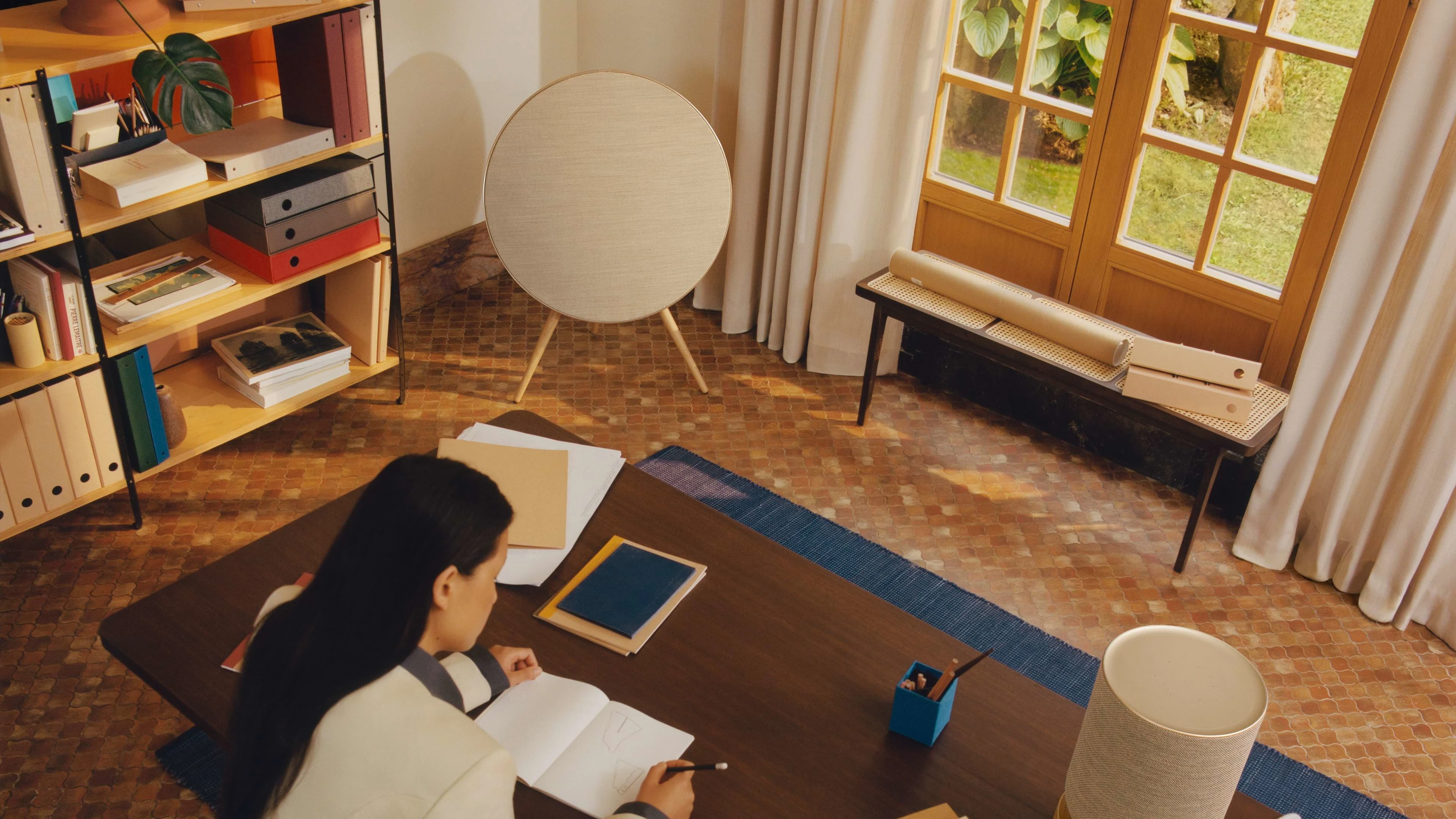 Person sitting at a desk with Beosound A9 in the background