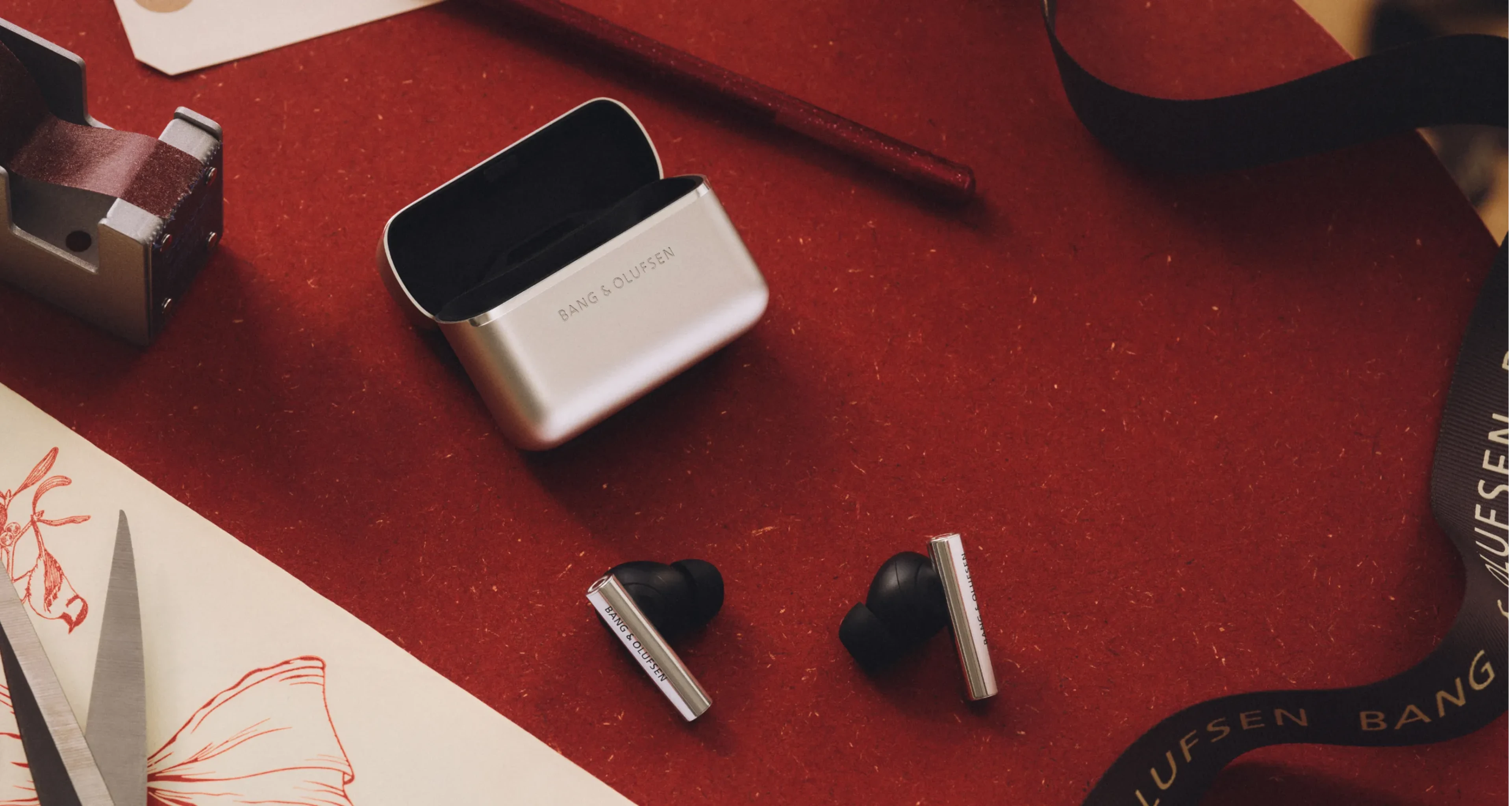 Beo grace earphones on a dark red background with holiday decoration in the background