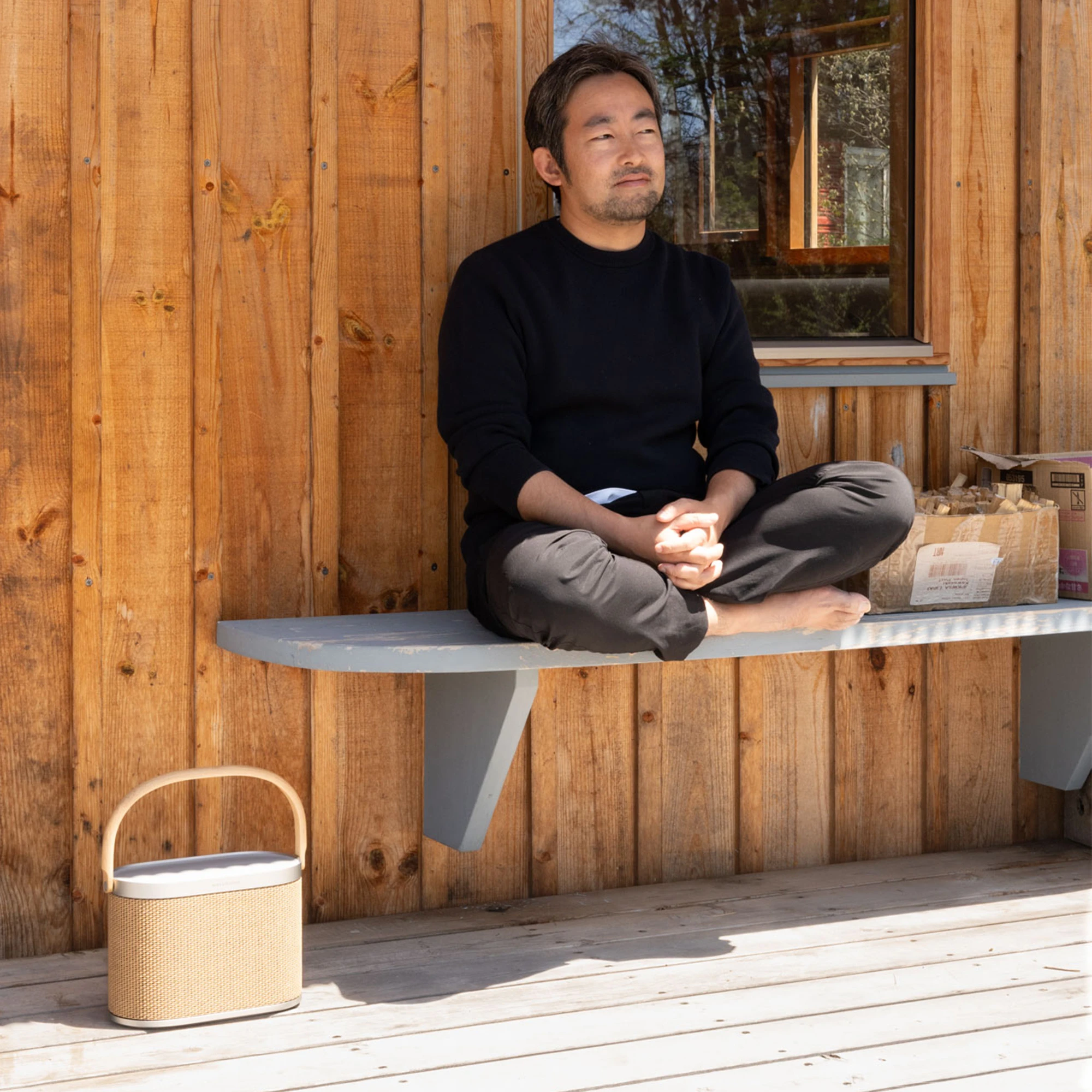 Oono sitting on a bench with Beosound A5