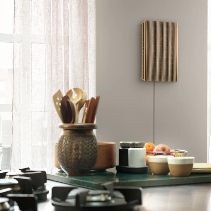 Beosound Level speaker in Gold Tone with Light Oak wall mounted in the kitchen