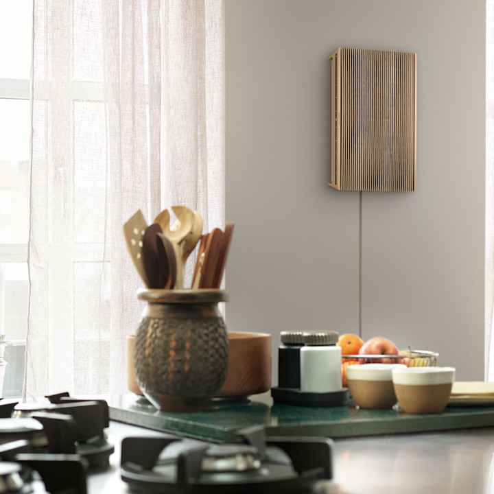 Beosound Level speaker in Gold Tone with Light Oak wall mounted in the kitchen