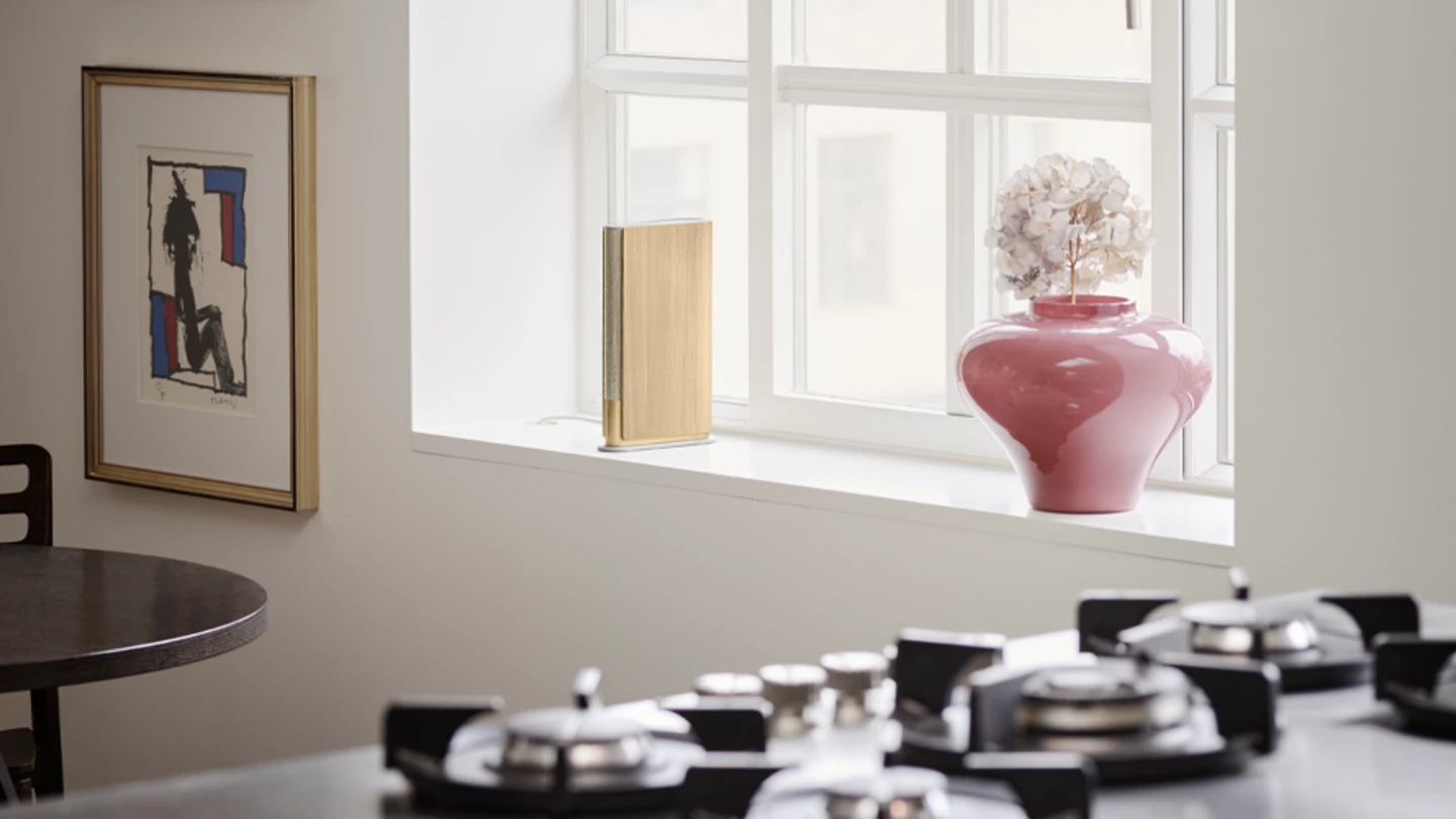 Beosound Emerge placed on a window sill in a bright kitchen