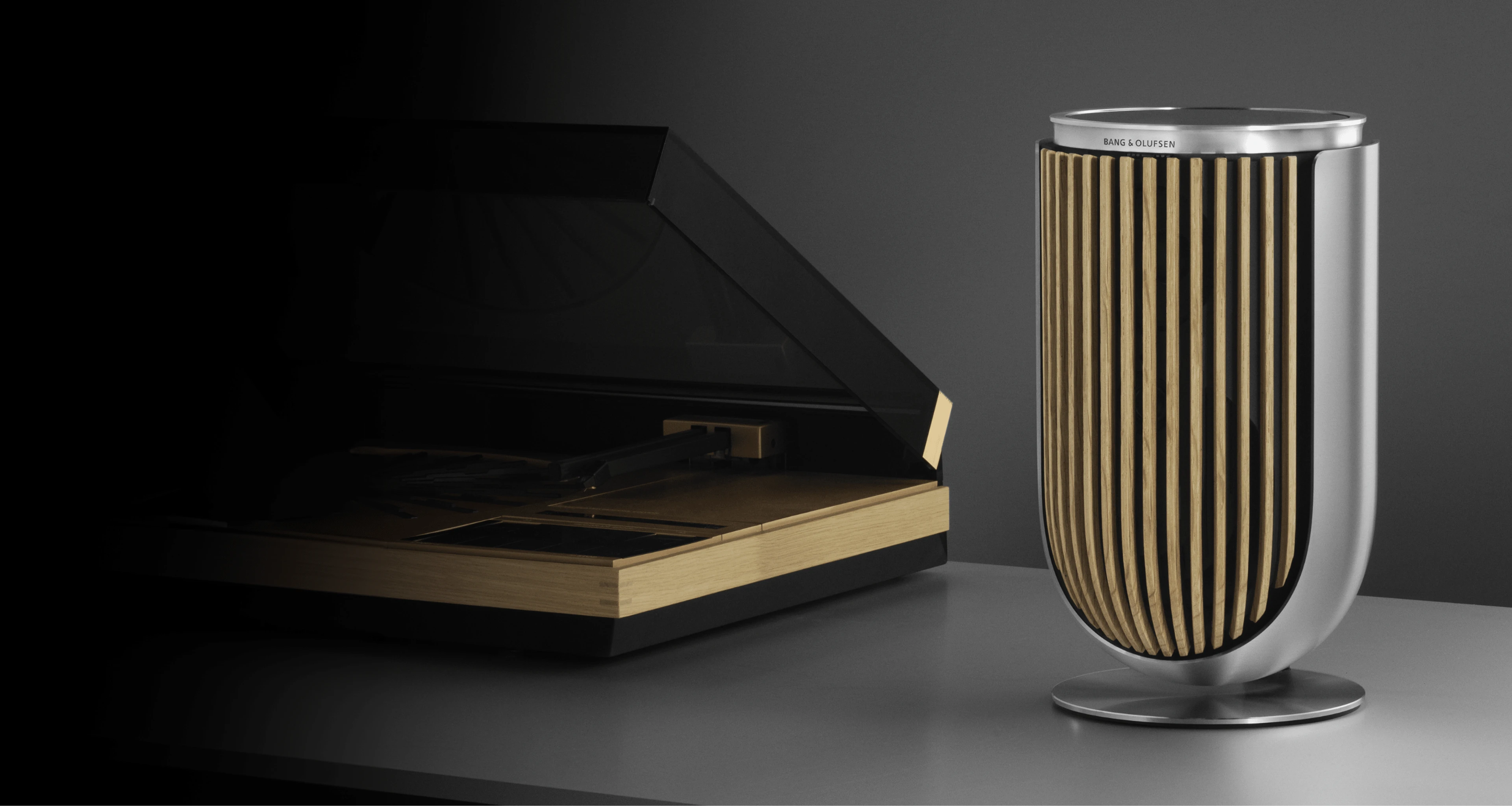 Beolab 8 speaker in natural with a wooden Oak cover on a table stand next to a Beogram 4000c record player