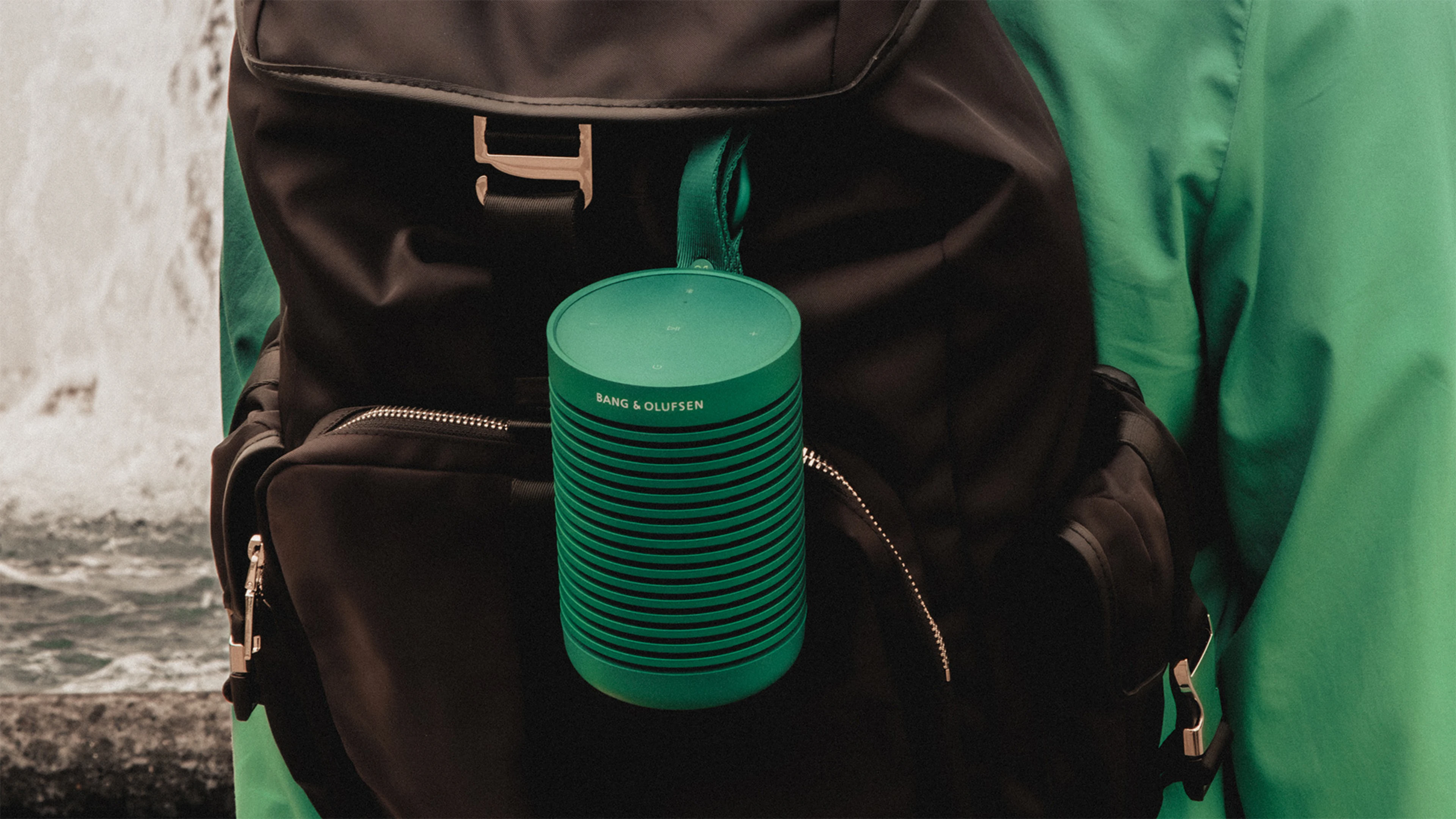 Beosound Explore Green hanging on a black backpack