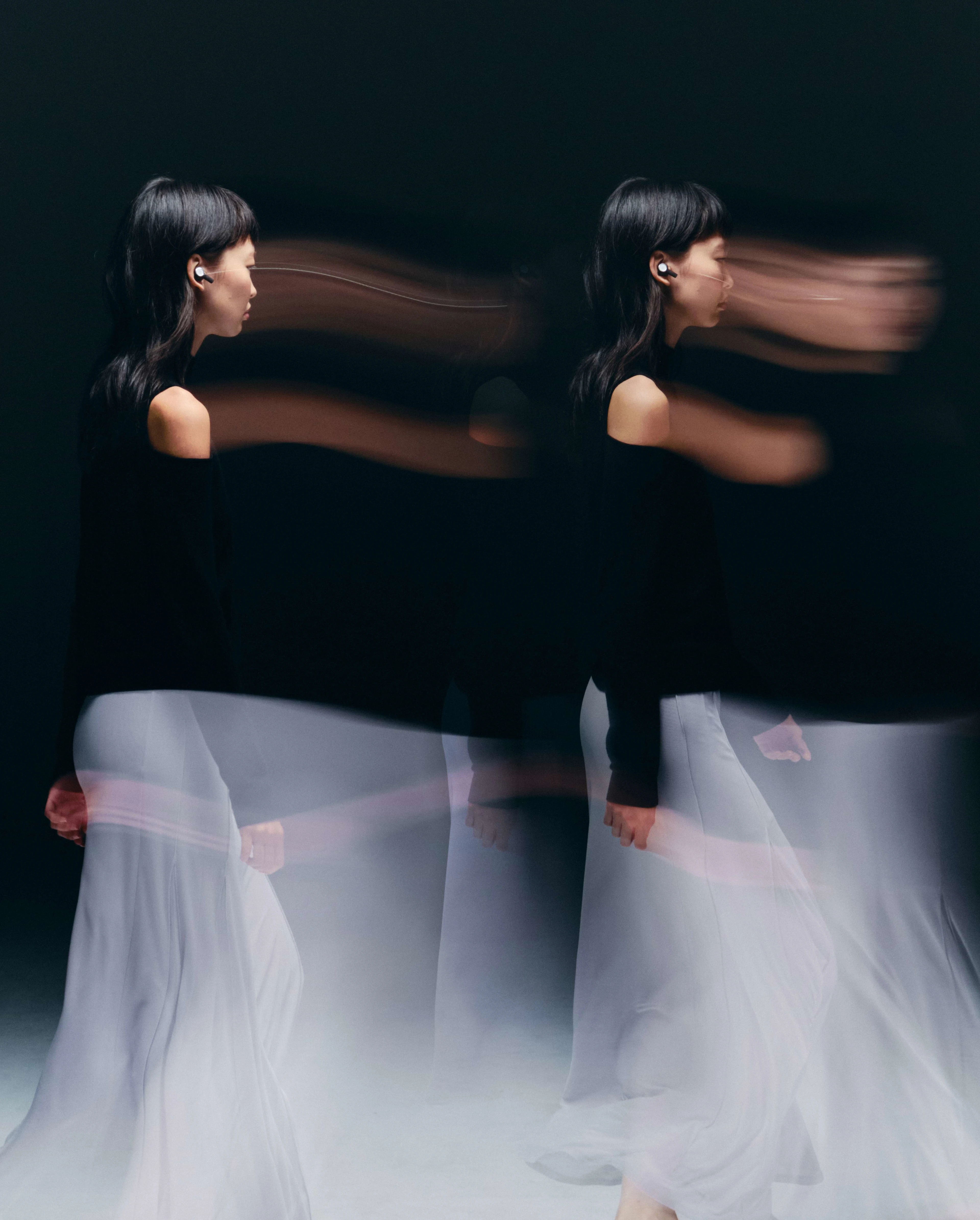 Lady walking with a white dress wearing the Beoplay Eleven