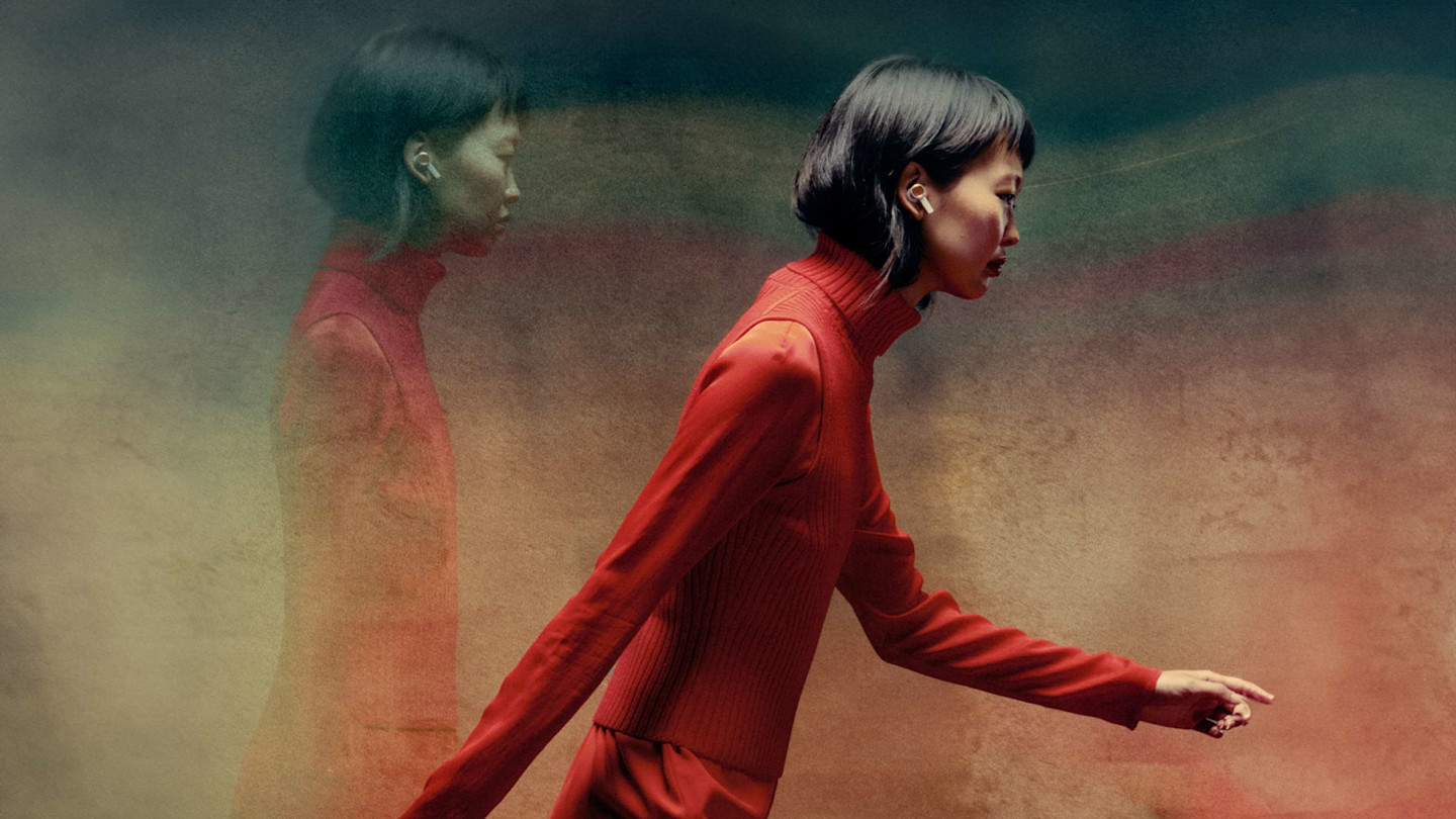 Lady in red wearing the Beoplay Eleven