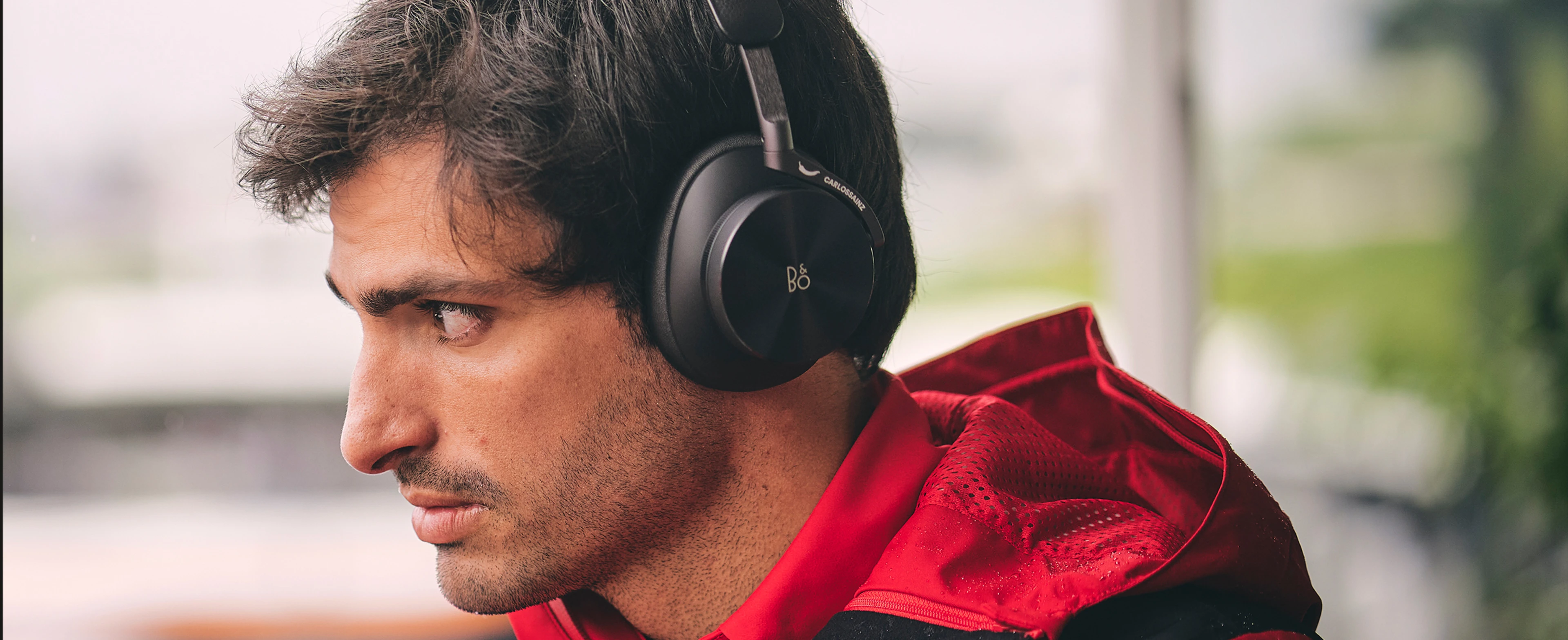 Carlos Sainz wearing Beoplay H95 Ferrari Edition headphones