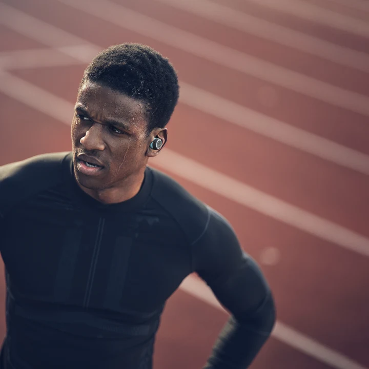 Man running on track with Beoplay E8 sport in his ears