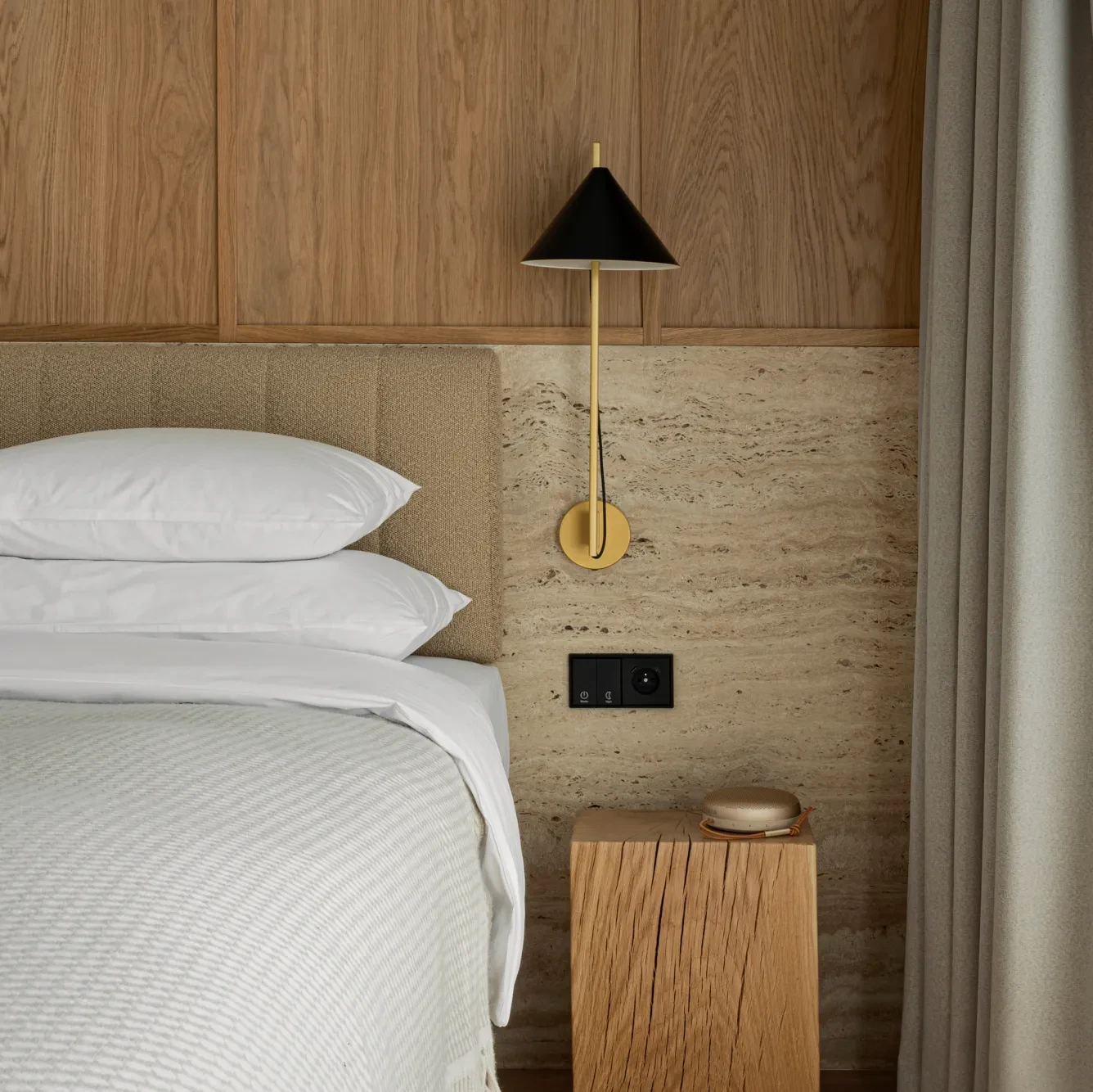 Inside the PURO hotel bedroom, Beoplay A1 standing on a night stand next to the bed.