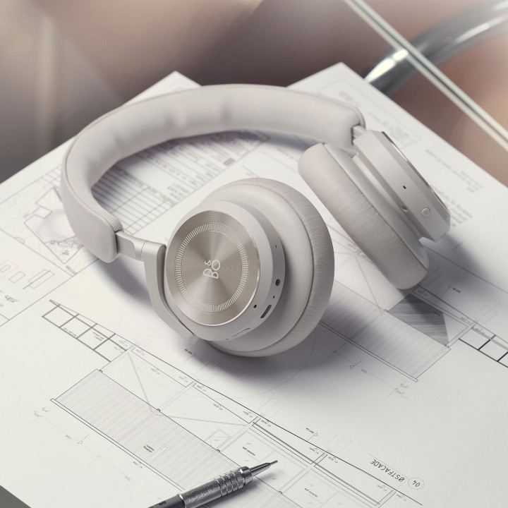 The headphones Beoplay HX laying on a desk with work documents