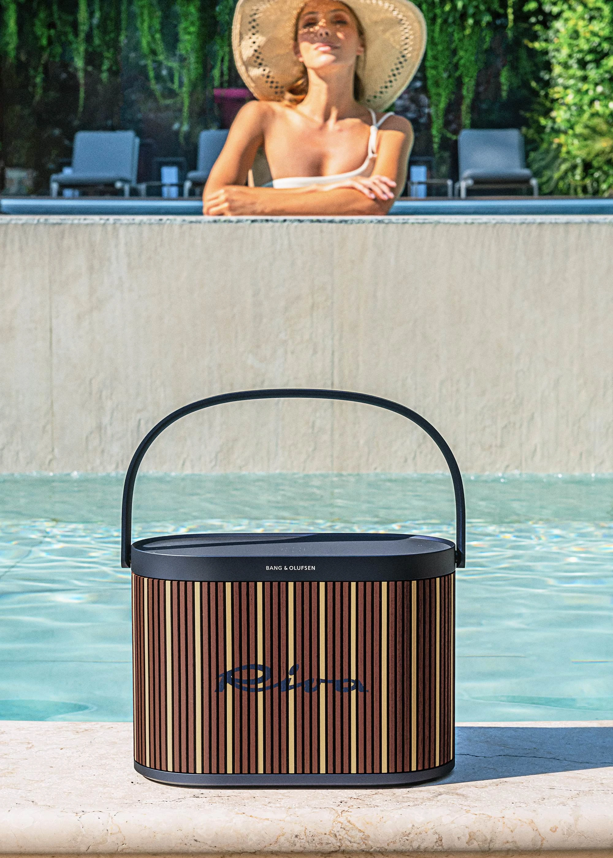 Beosound A5 Riva edition standing in front of a pool while a person is in the background