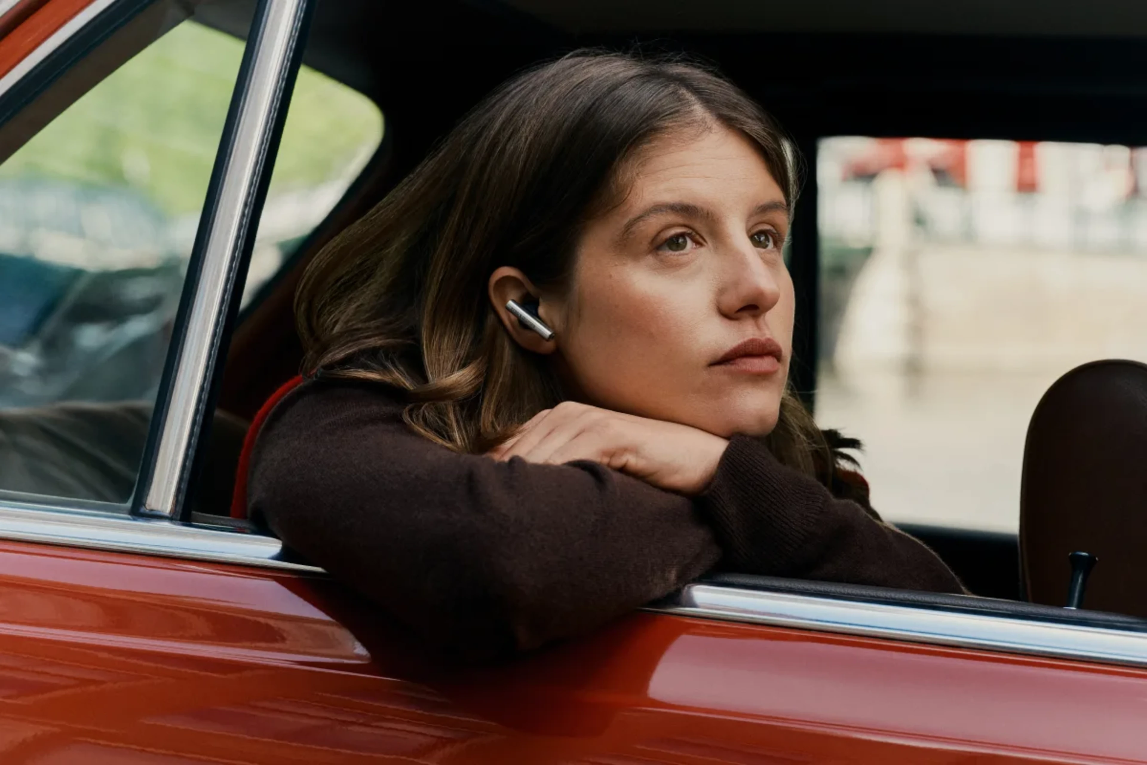A woman in a car, looking out of the window, wearing Beo Grace