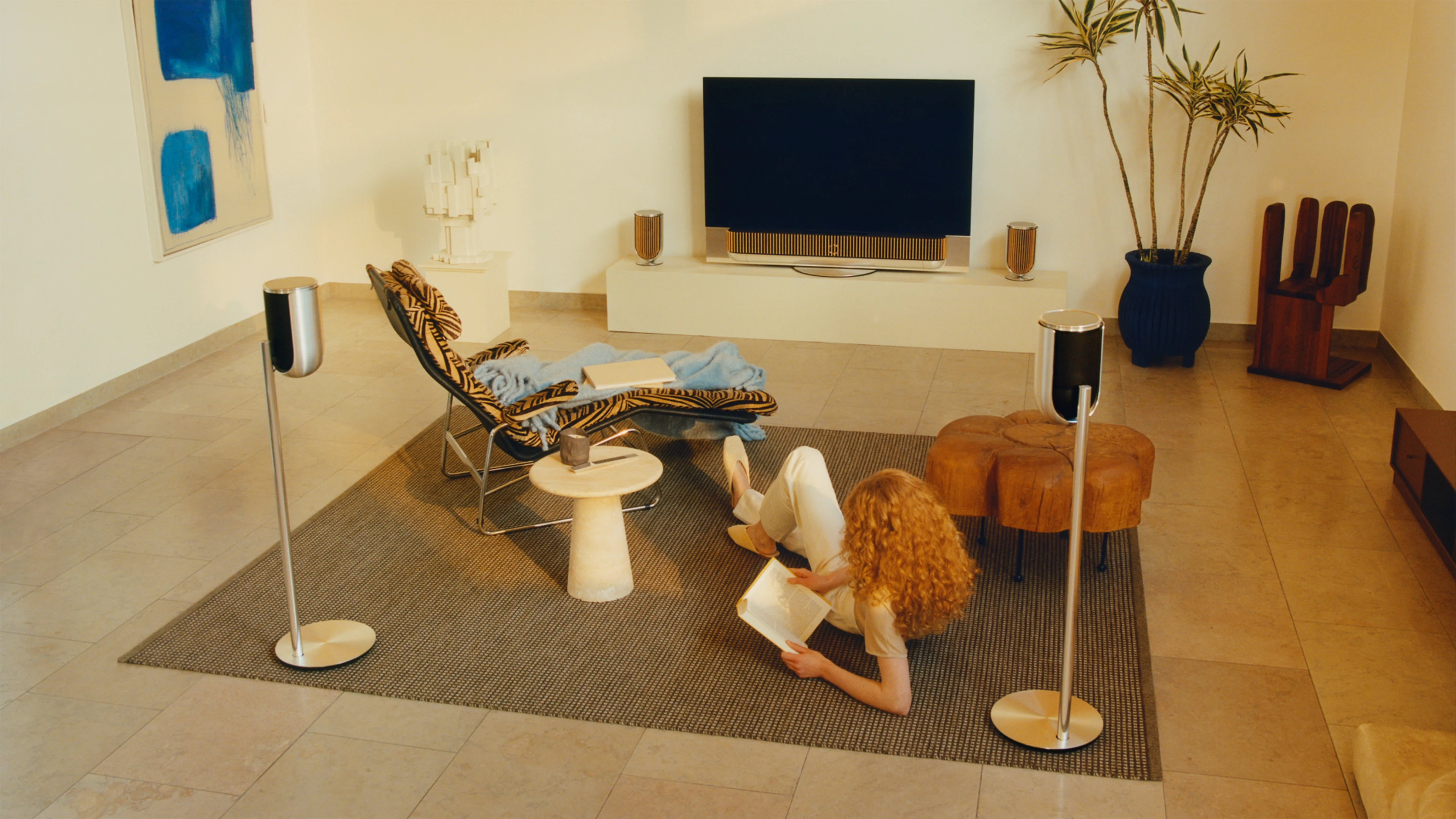 Two people sitting in a living room surrounded by B&O products
