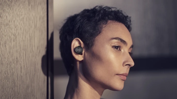 A woman wearing Beoplay EQ earphones.