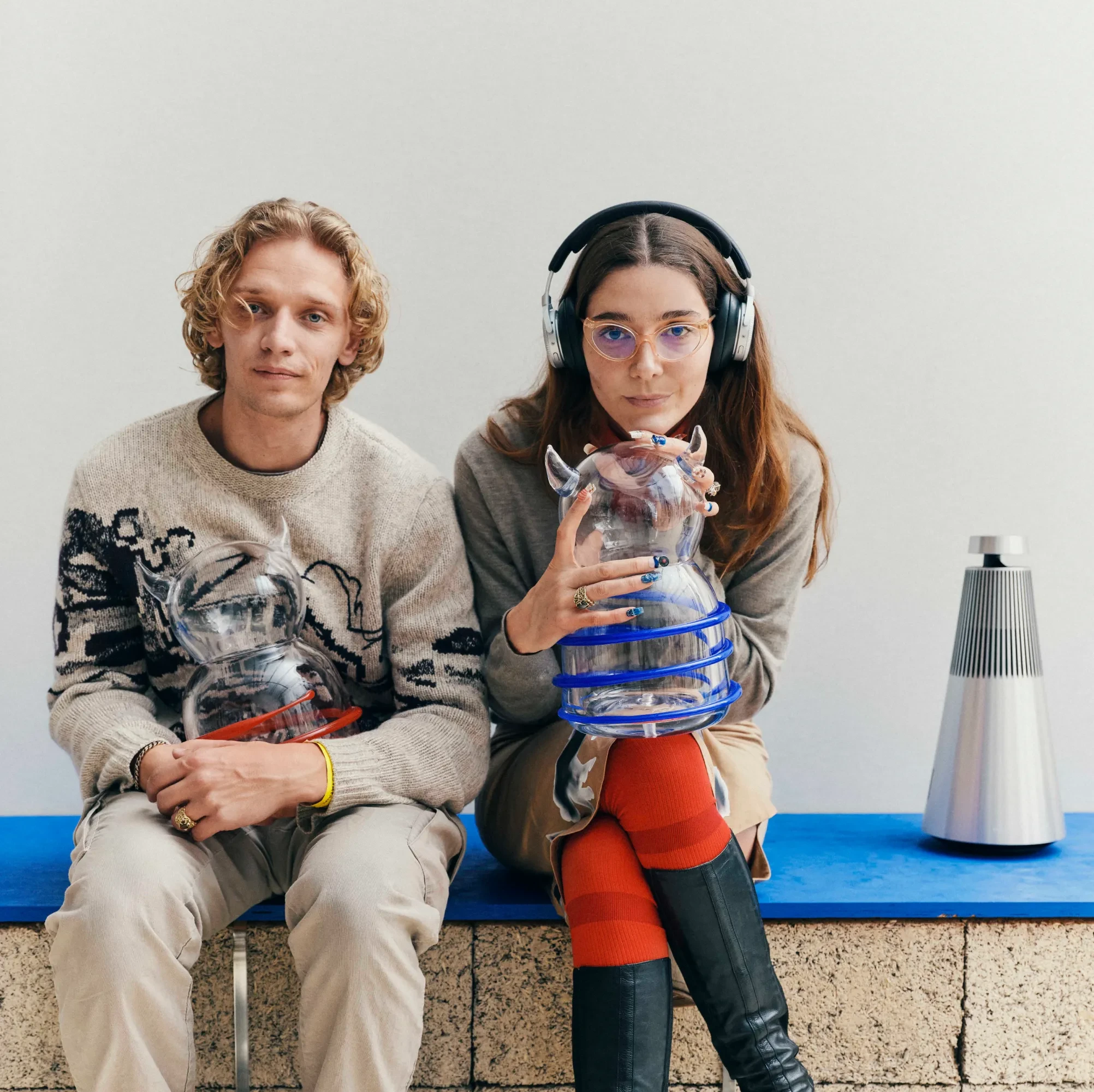 2 people sitting with a glass figure each