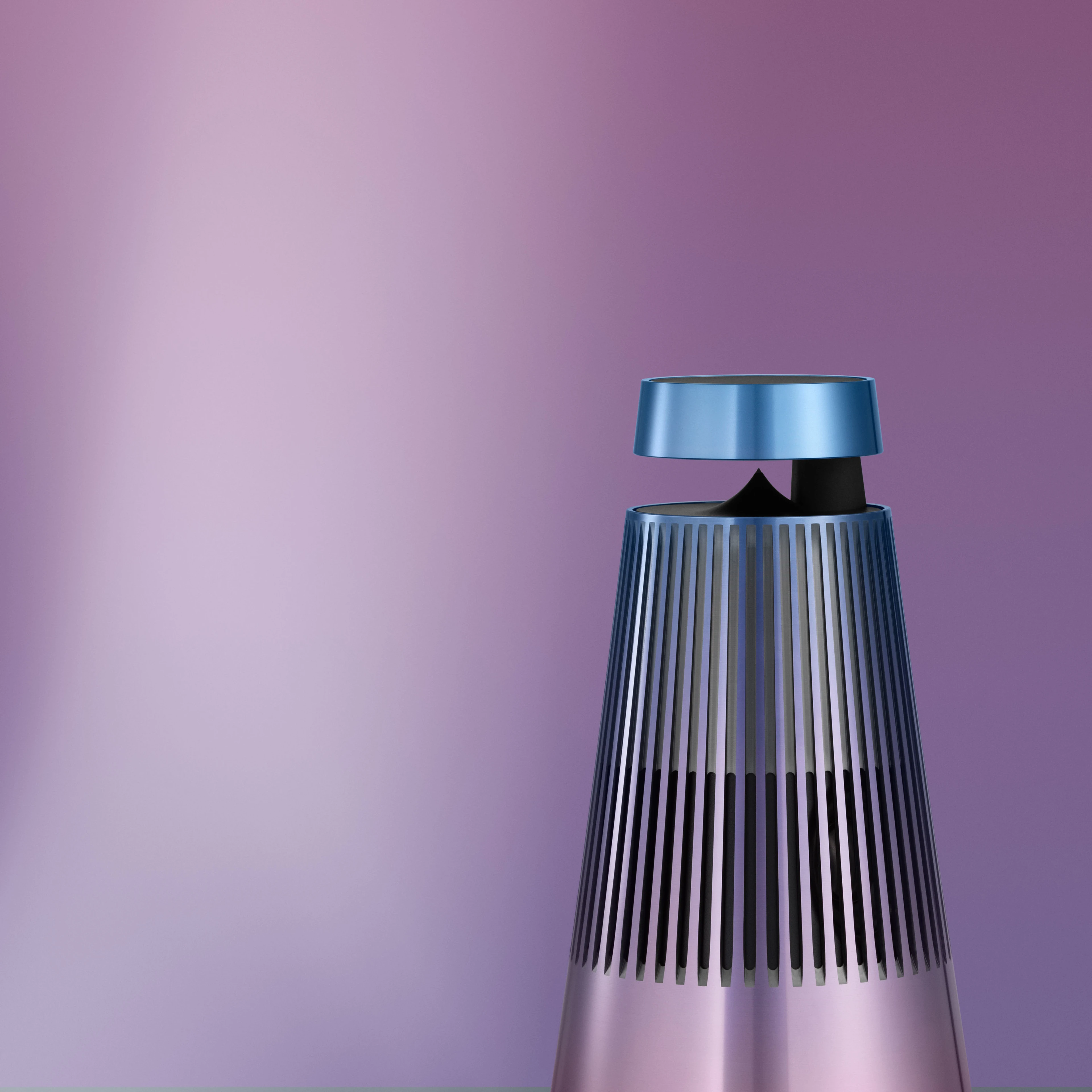 Image of the top part of the Beosound 2 Atelier Limited Edition speaker in the colour Daybreak Blossom that is a gradient colour of pink, blue and purple.